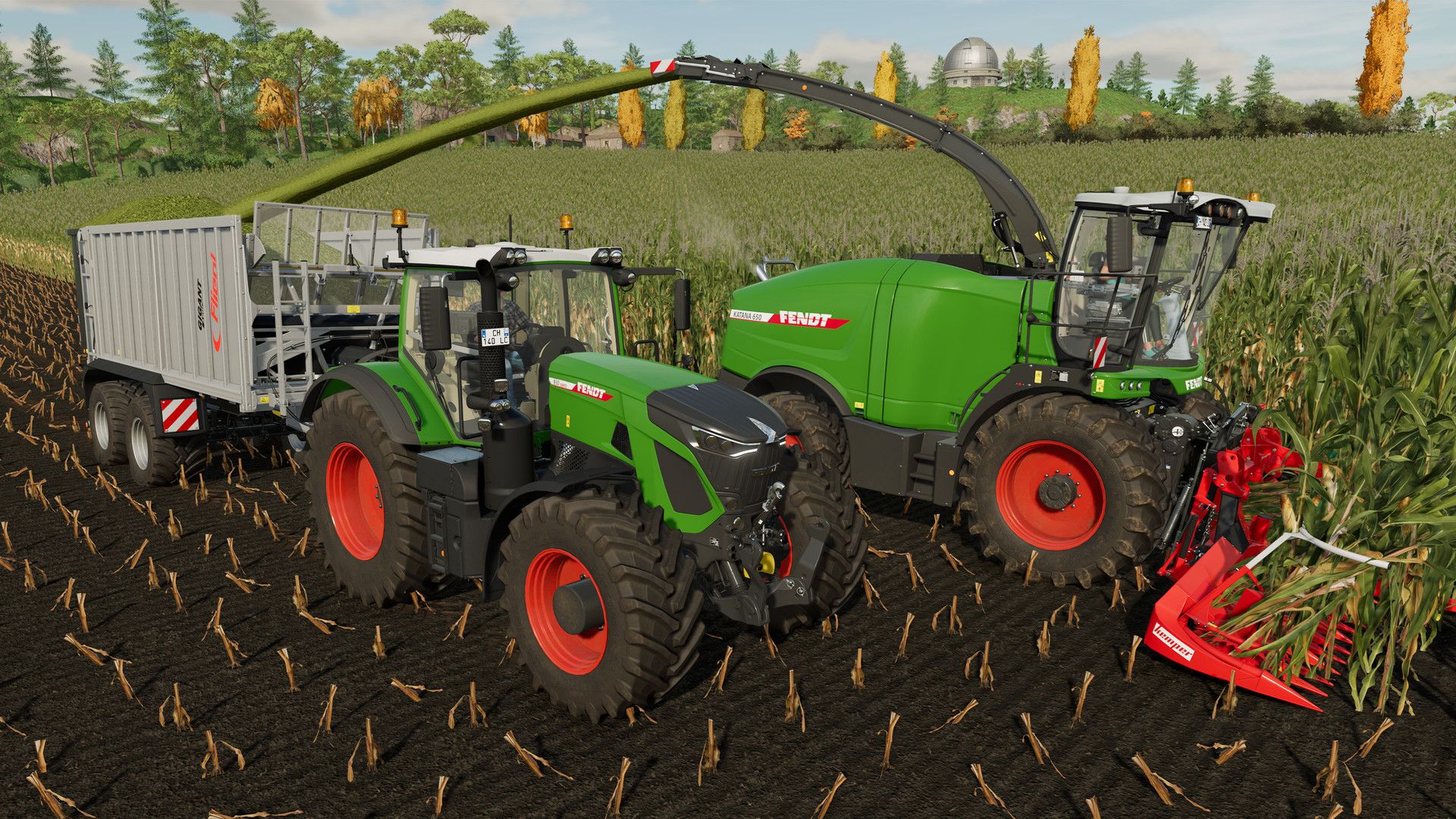 Two machines work together, with the harvesting machine feeding its load into a trailer.