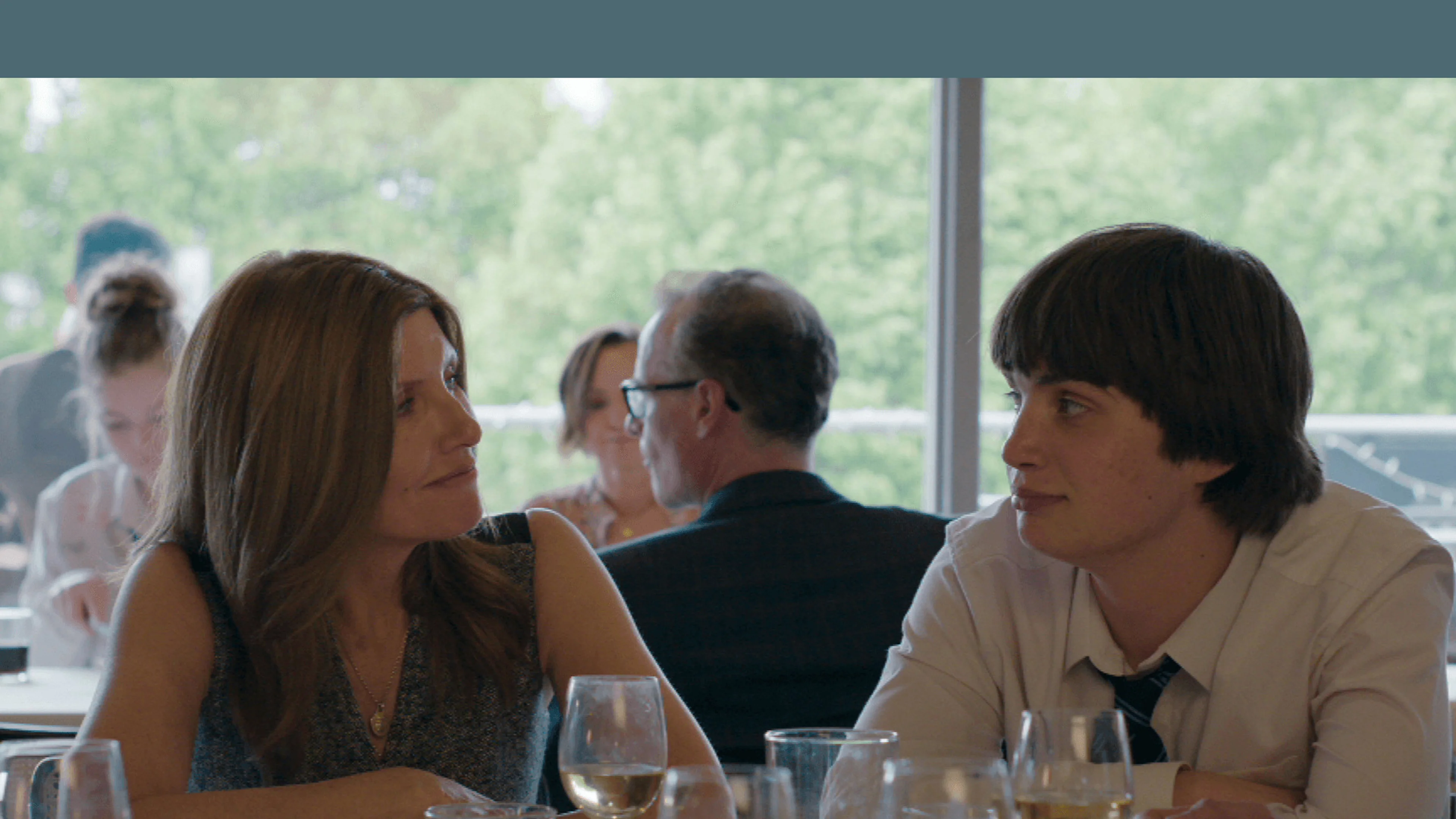 Sharon Horgan as Alex looks at Aran Murphy as Ruari across a restaurant table in YOUTH.