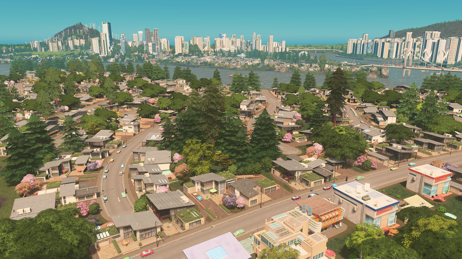 A low-rise neighbourhood leads toward a taller city skyline beside the water.