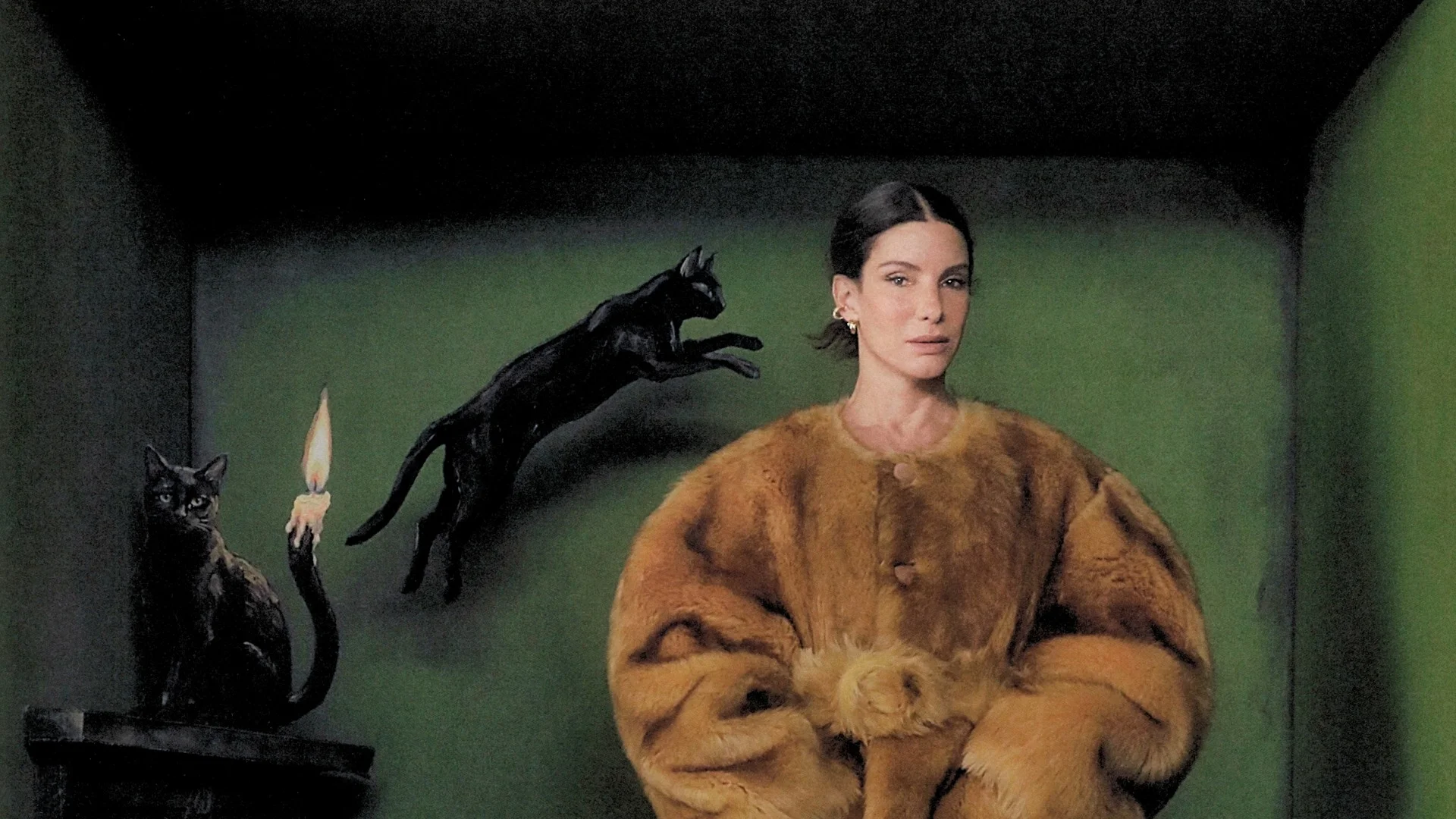 Sandra Bullock stands in a brown coat beside black-cat artwork during her September 2026 cover shoot.