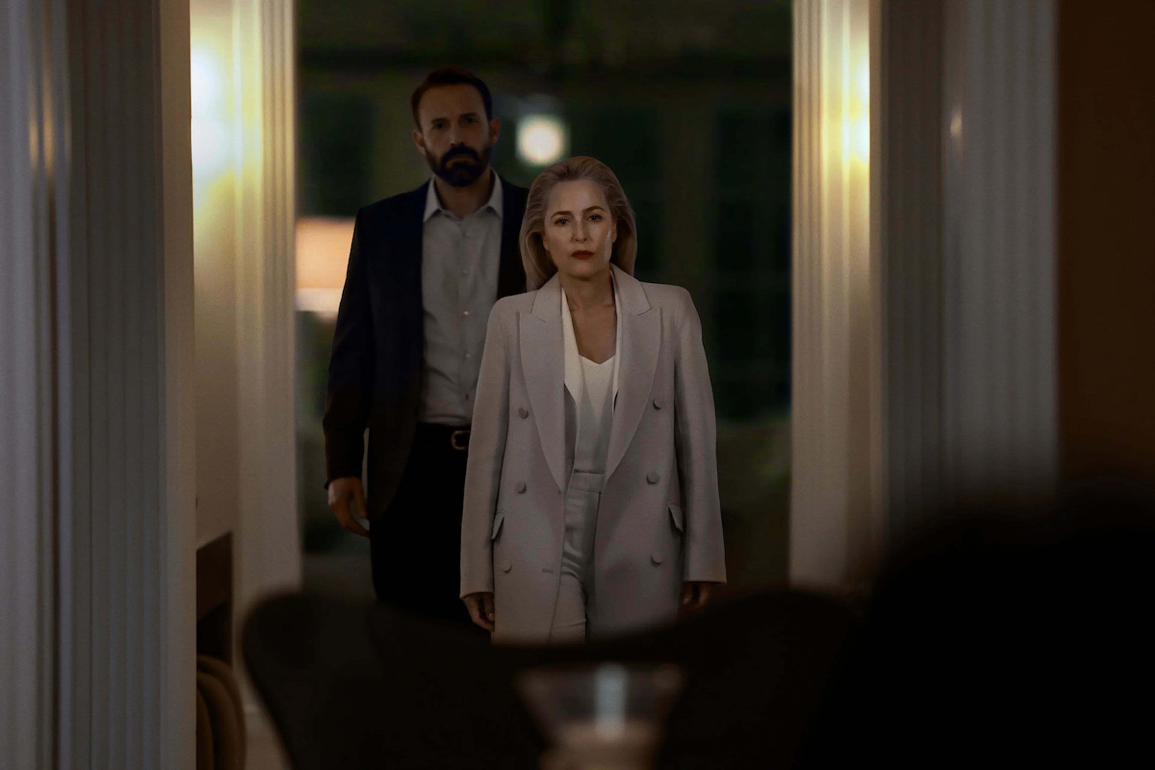 Gillian Anderson stands in front of Ben Affleck during a scene from Animals.