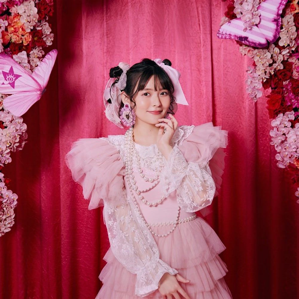 Japanese voice actor Sumire Uesaka poses against a vivid floral backdrop in an official King Records portrait.