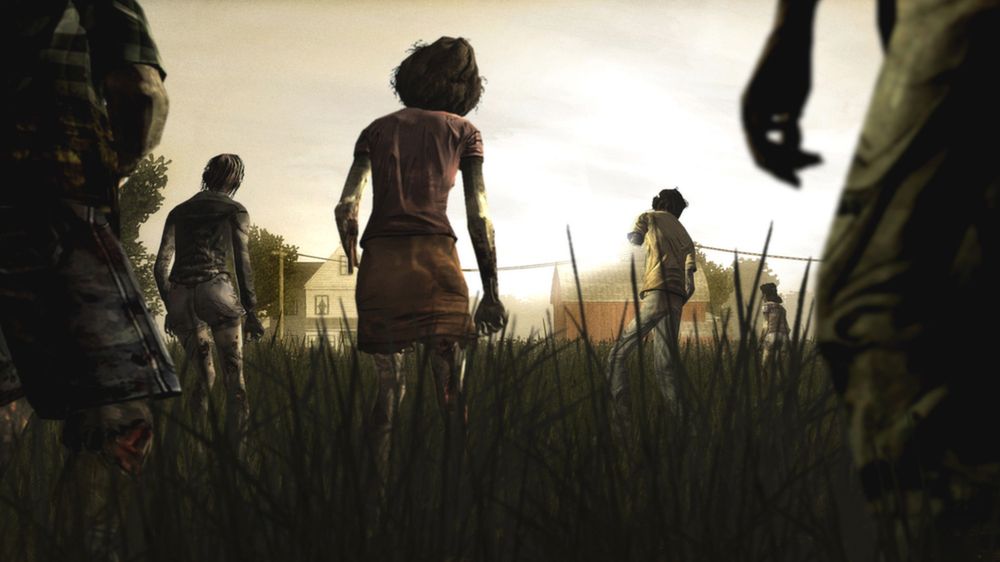 Several walkers move through tall grass toward houses in the distance.