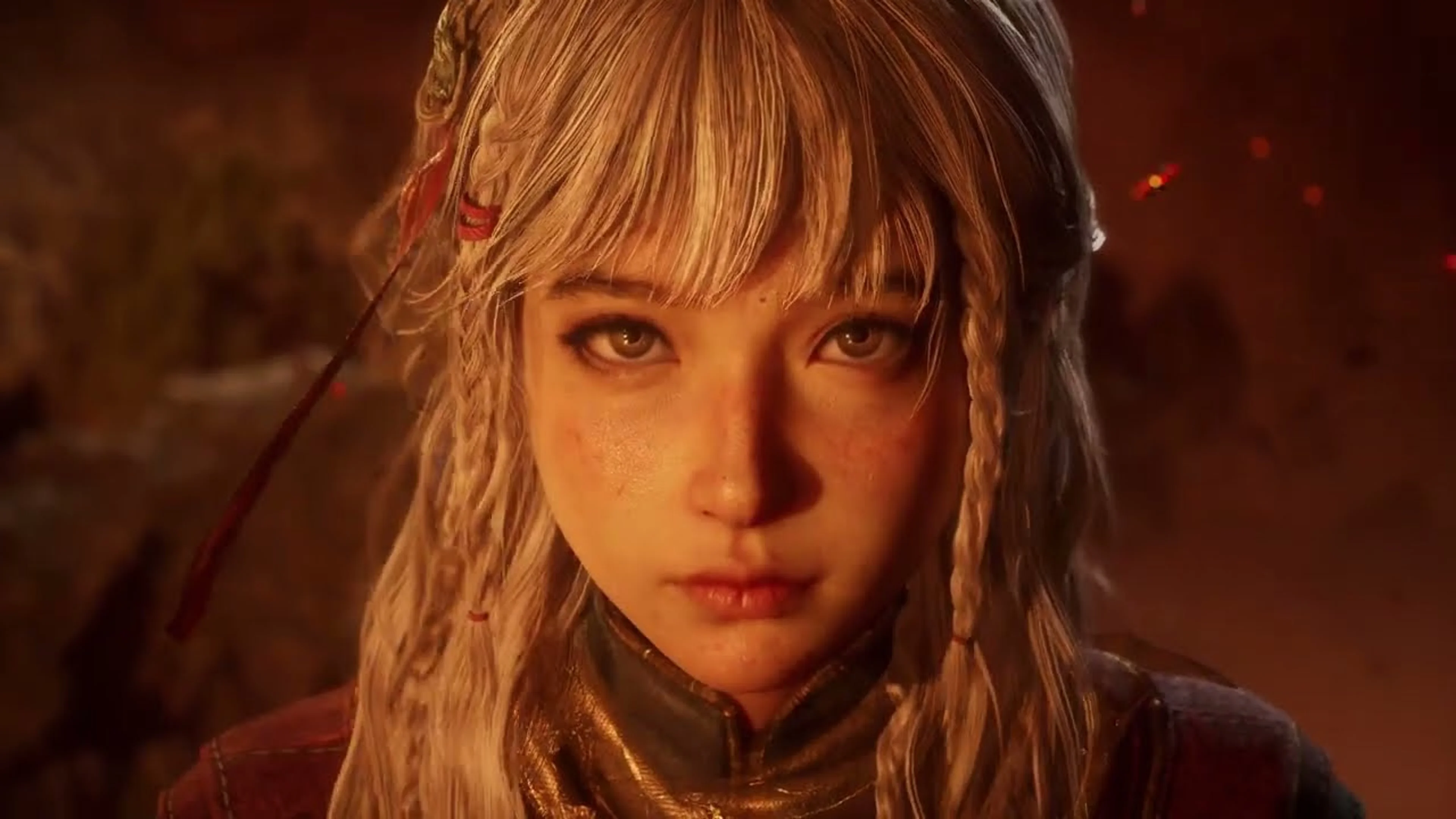 A blonde companion looks directly at the camera in warm firelight during a cinematic moment from the Nodusfall trailer.