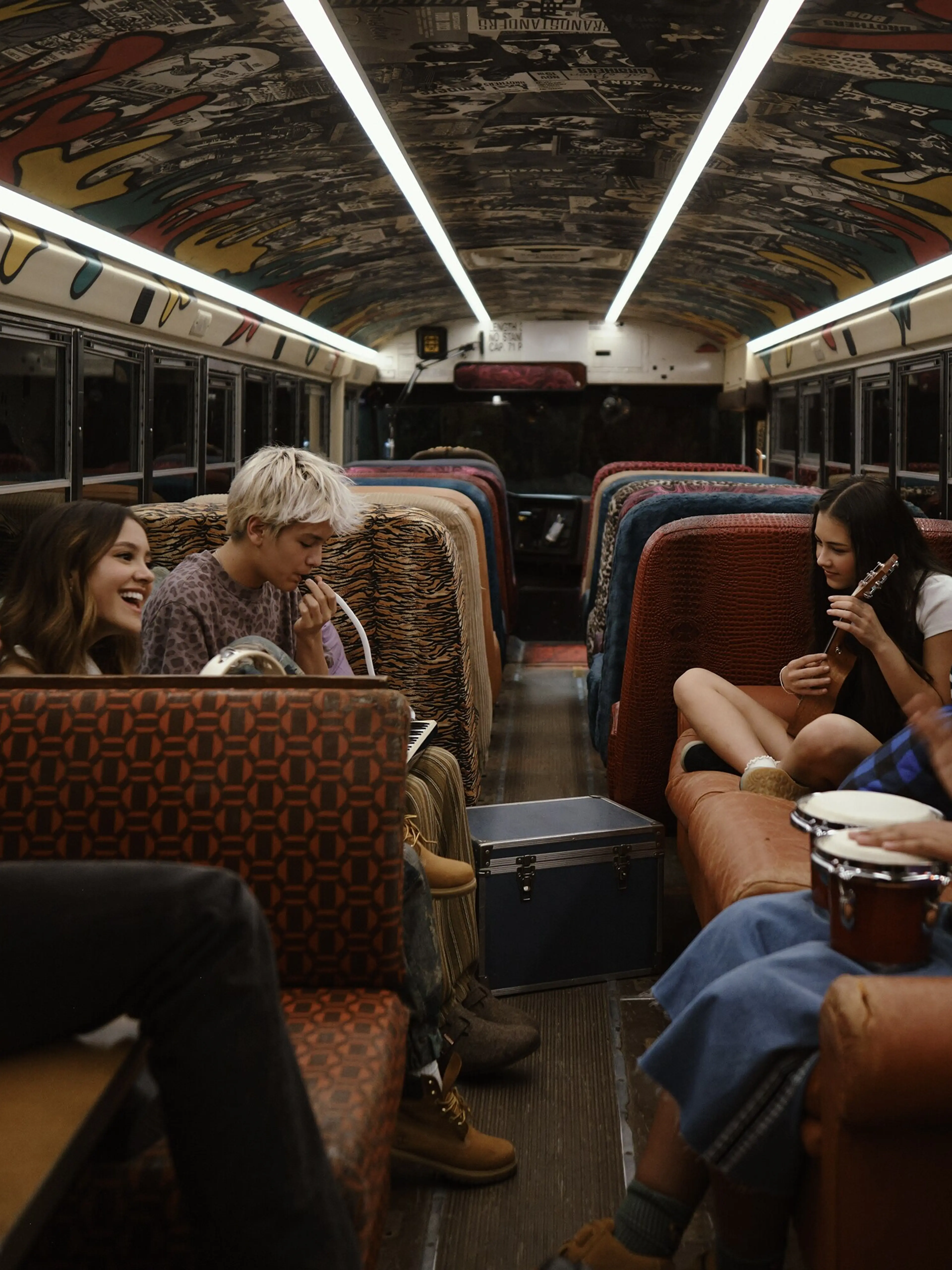 The new Camp Rock 3 campers gather with their instruments inside a bus.