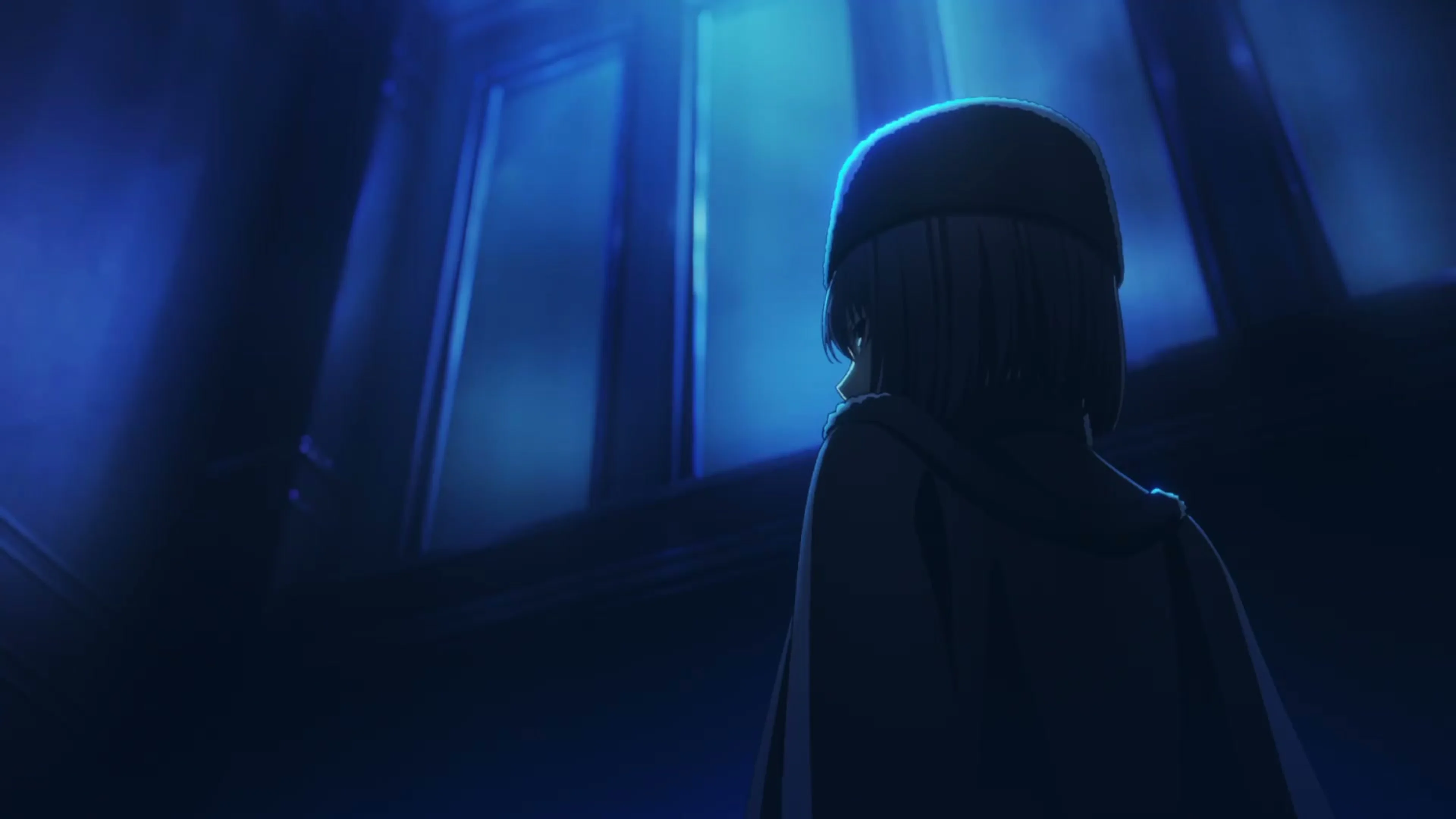 A girl in a dark hat and coat stands beside a blue-lit window.
