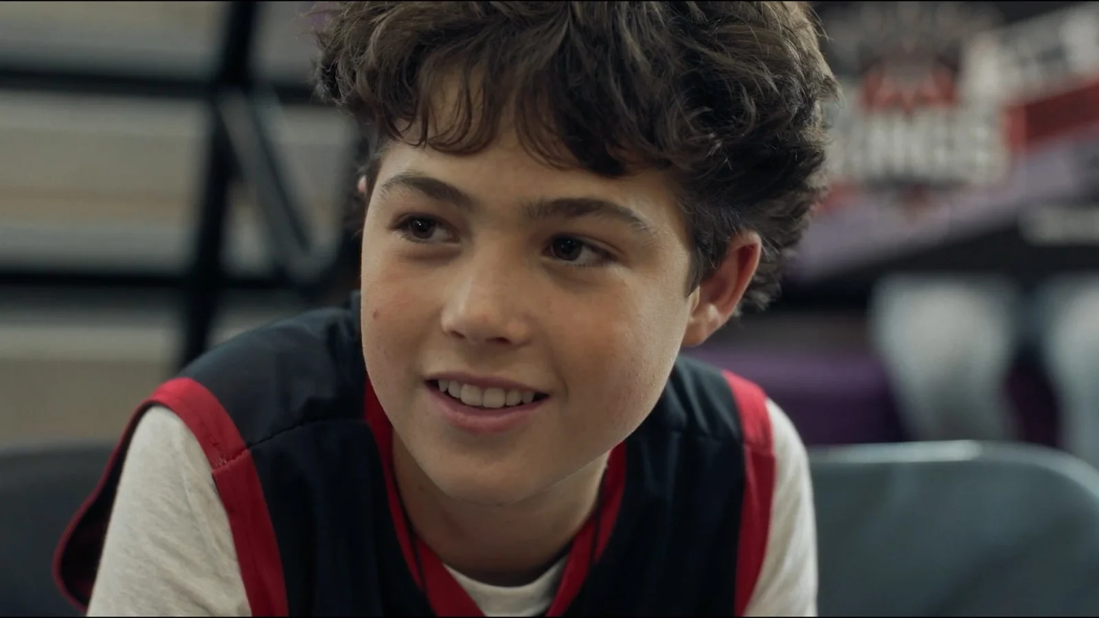 Dylan Friedman as Caden Isaacs smiles while seated in a gym in Last Shot.