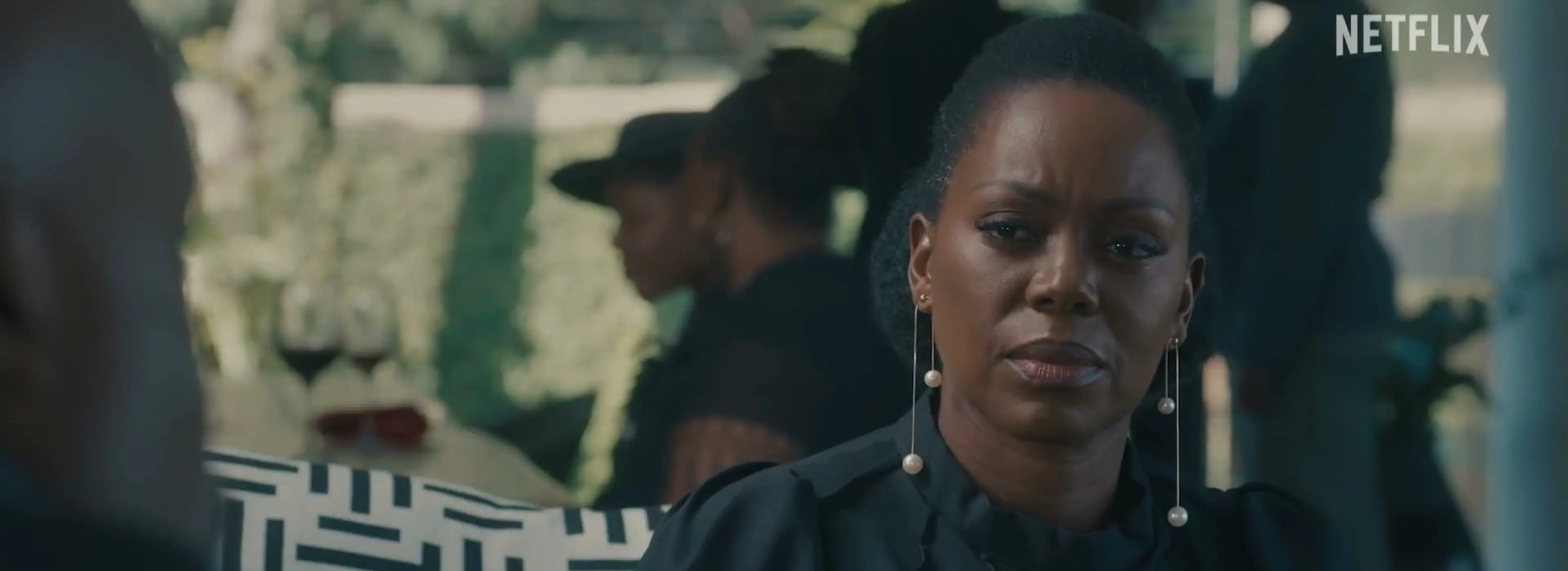 A woman in black looks toward another person in the Blood Legacy season 2 trailer.