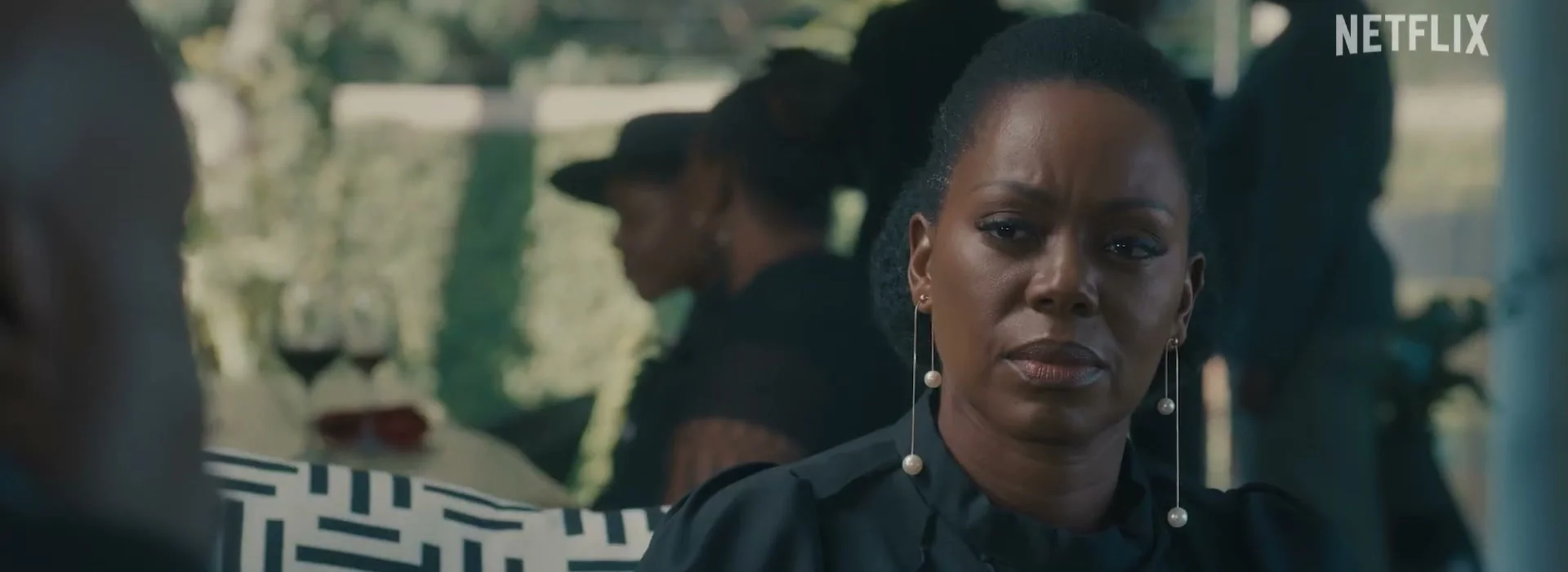 A woman in black looks toward another person in the Blood Legacy season 2 trailer.