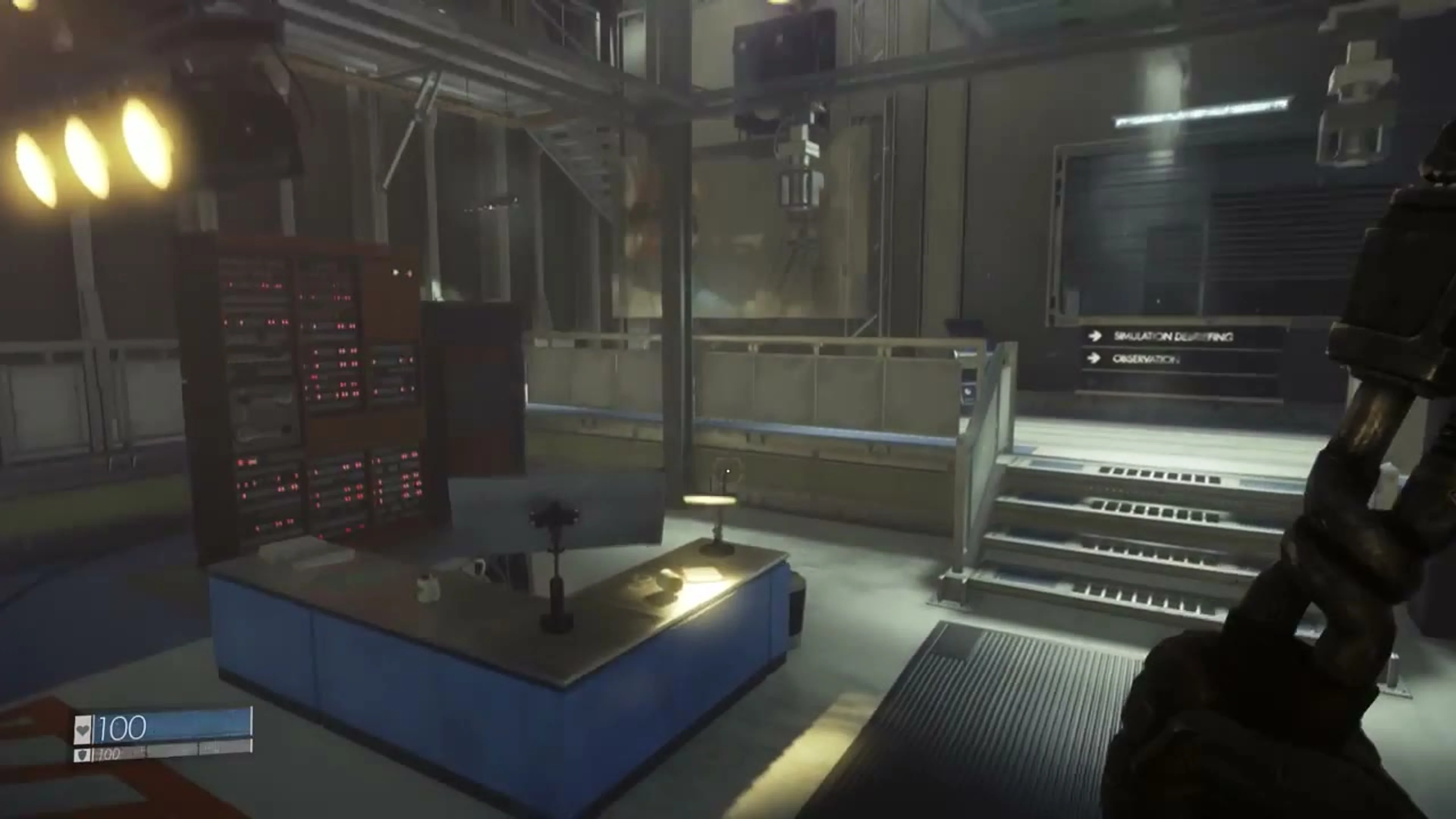 Industrial simulation lab behind the apartment set, with stairs and directional signs.