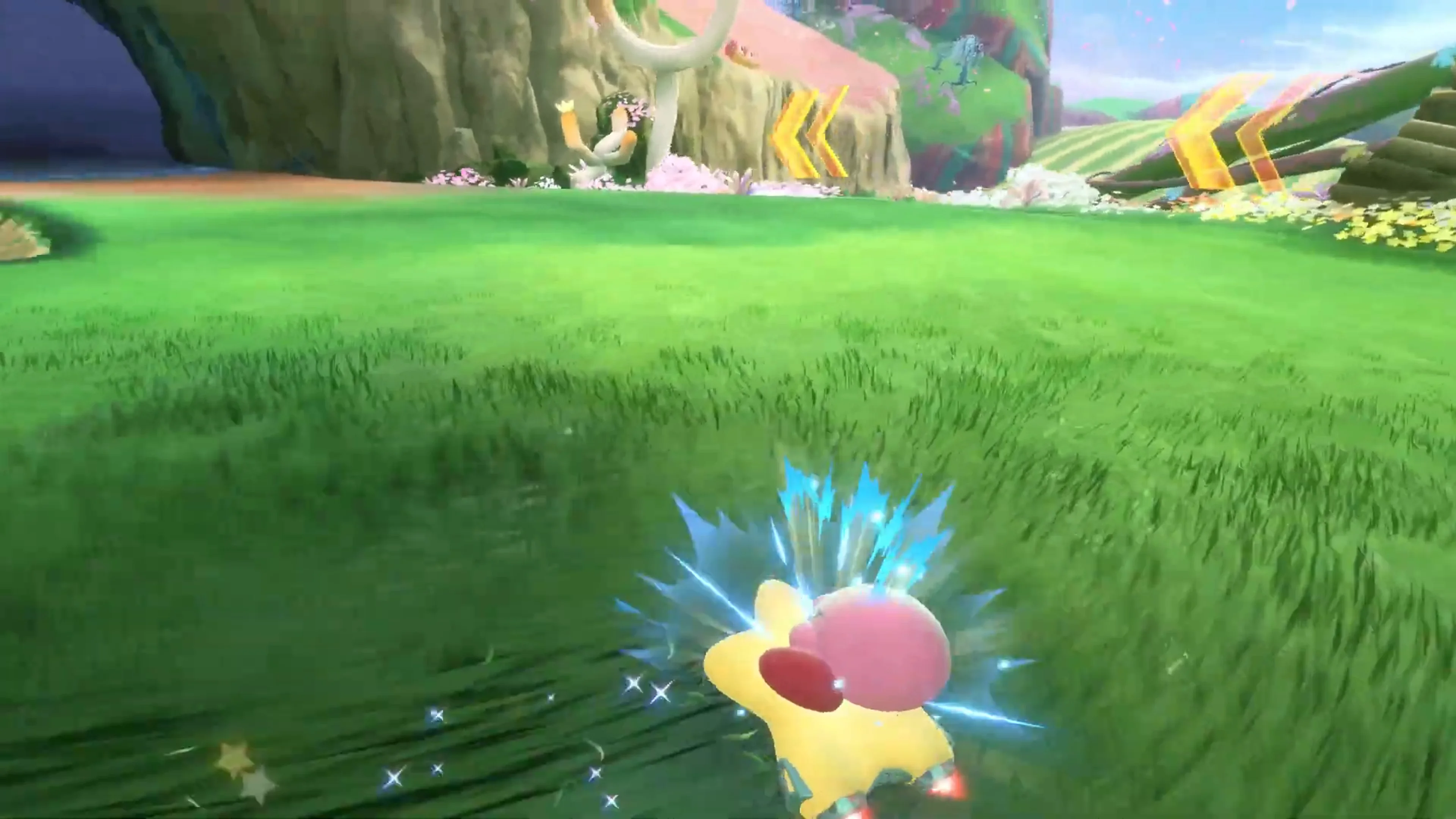 Official Nintendo UK Kirby Air Riders gameplay frame showing blue sparks around Kirby’s Warp Star during a left-hand drift.