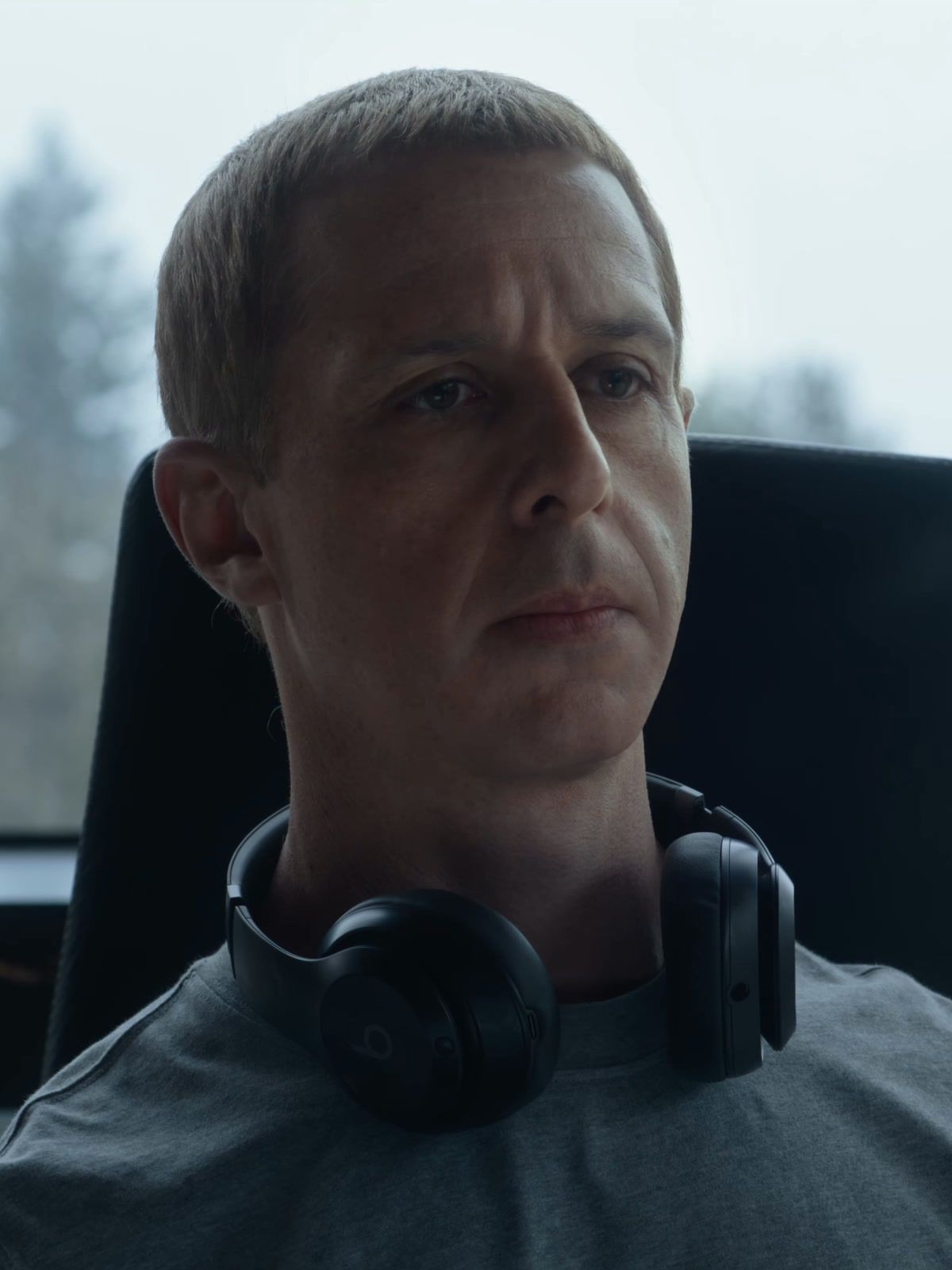 Jeremy Strong as Mark Zuckerberg sits with headphones around his neck in The Social Reckoning.