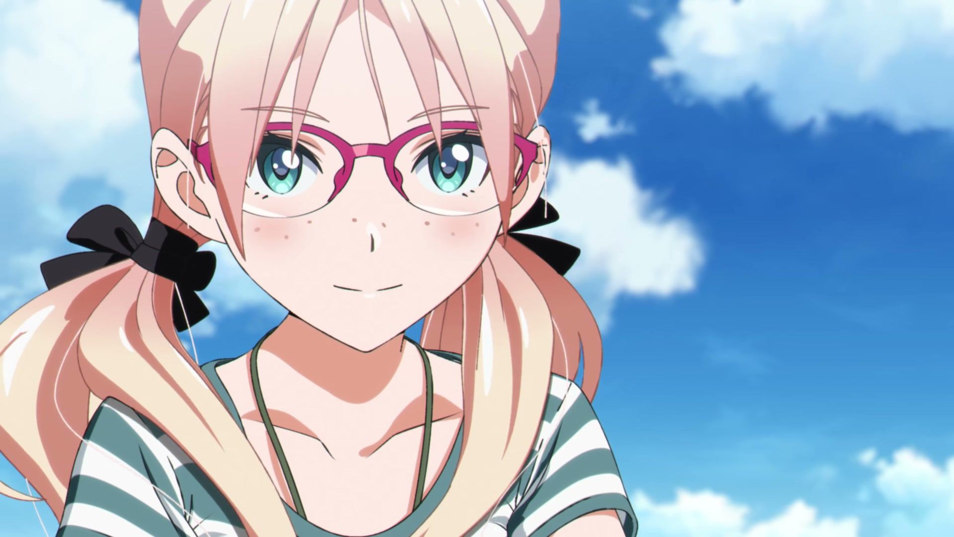 A young woman with pink hair and glasses smiles beneath a clear blue sky.