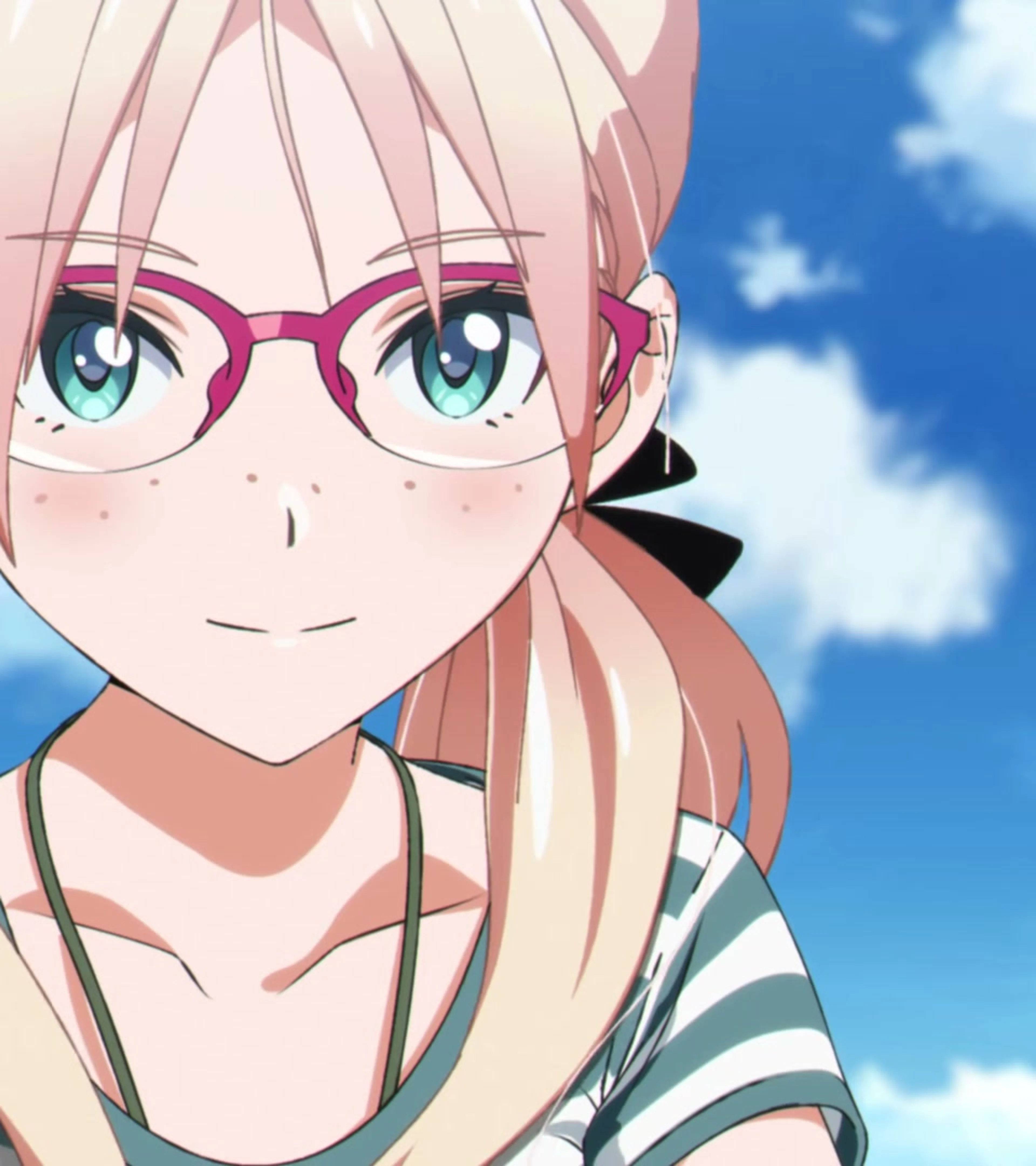 A young woman with pink hair and glasses smiles beneath a clear blue sky.