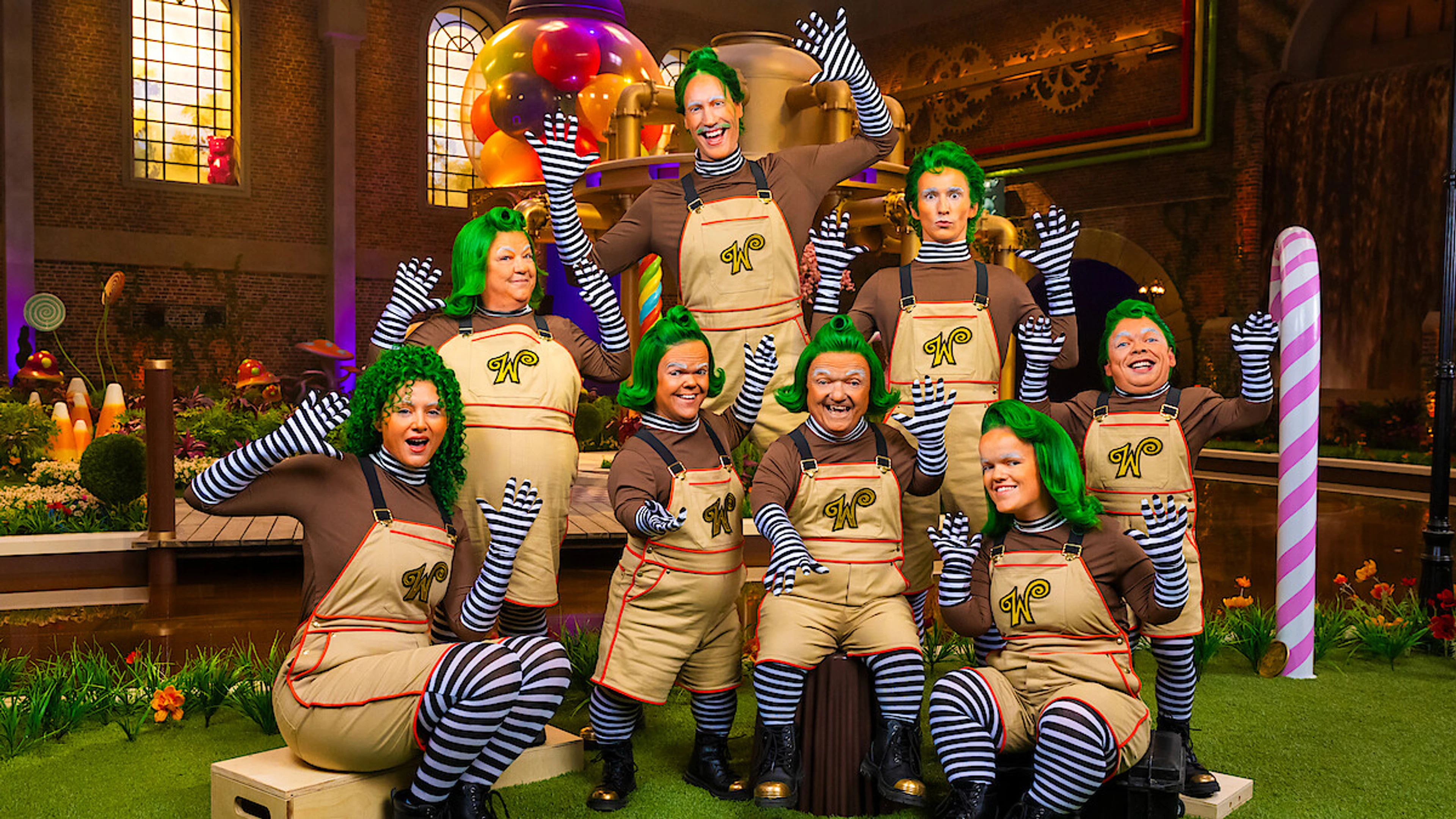 The nine Oompa-Loompa performers from Wonka’s The Golden Ticket stand together on set.