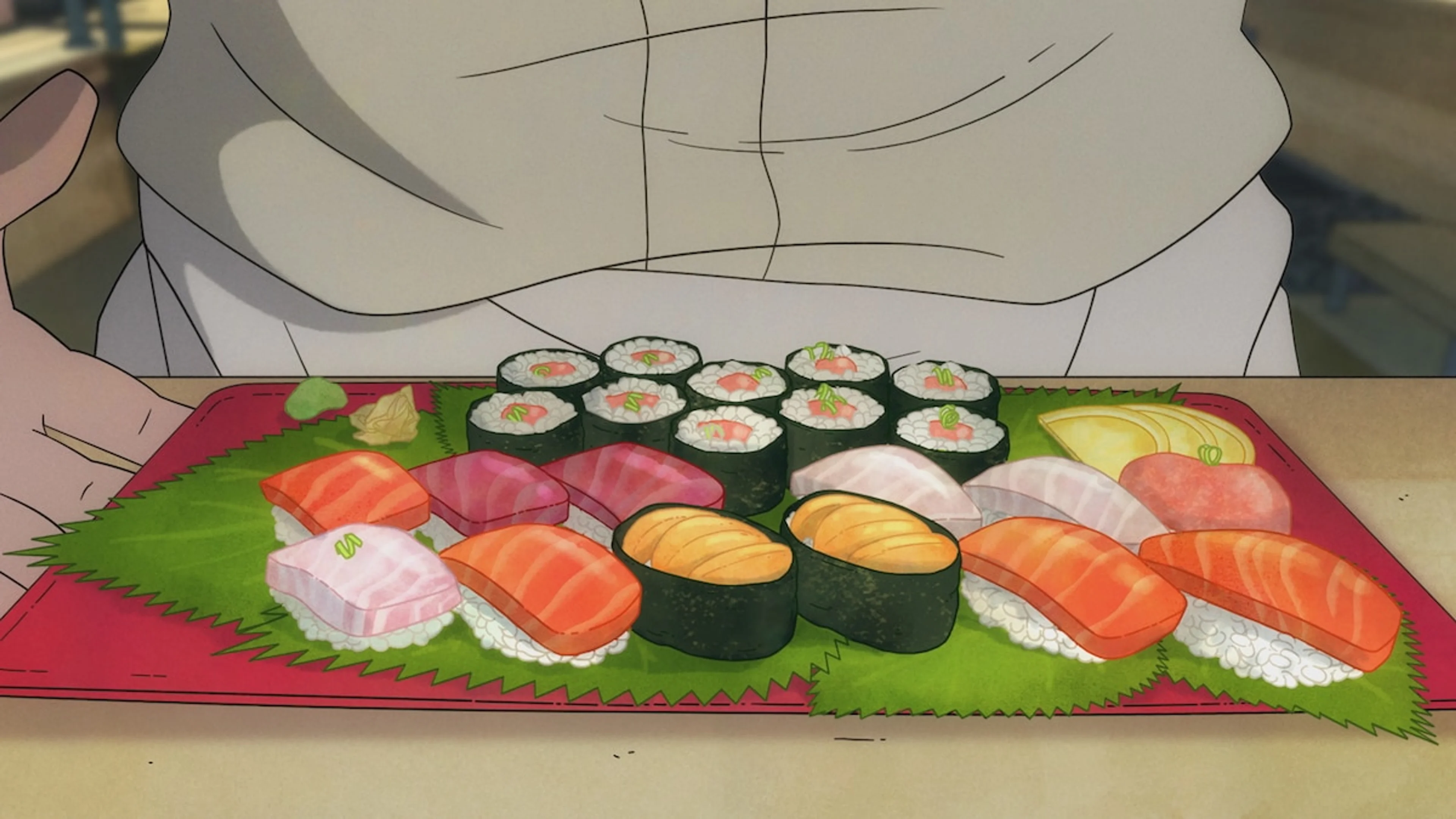 A tray holds neatly arranged sushi in front of a person wearing a white outfit.