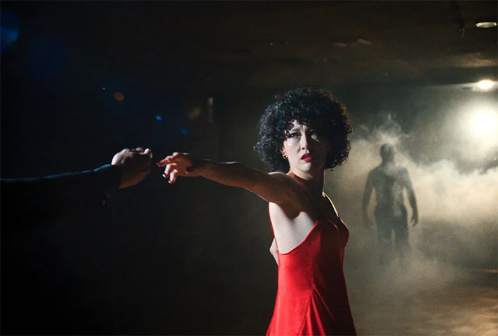 Rinko Kikuchi dances in a red dress in a scene from Ha-Chan, Shake Your Booty!