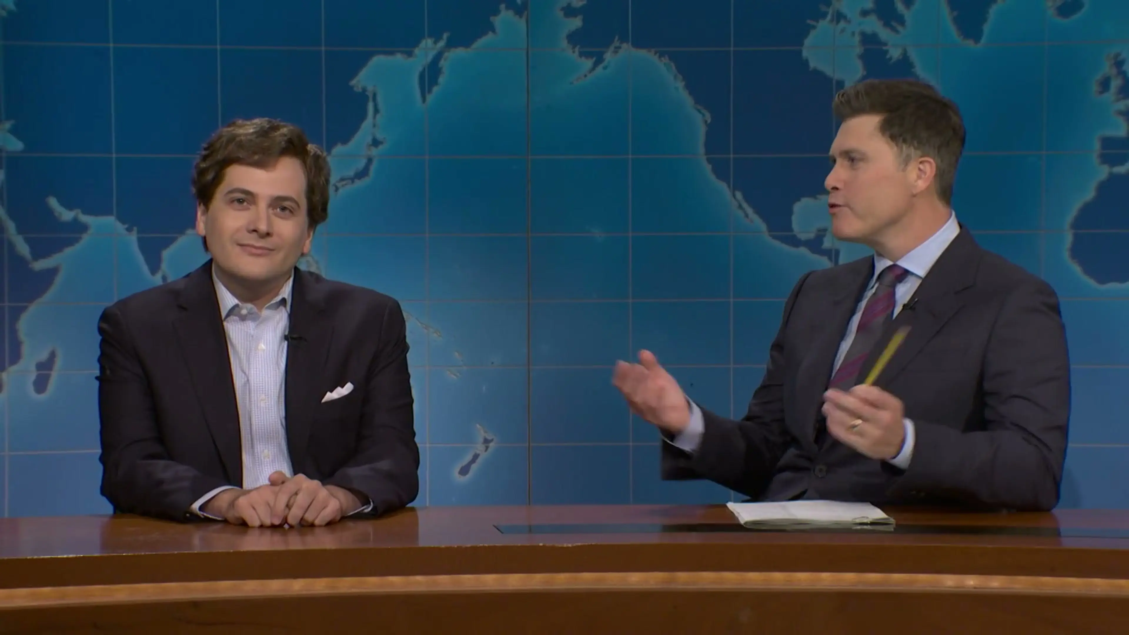 Jeremy Culhane as Tucker Carlson sits beside Colin Jost during Saturday Night Live Weekend Update.