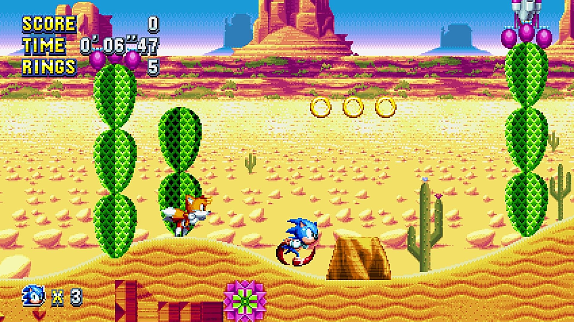 Sonic and Tails cross a desert platform with cacti, cliffs and floating gold rings.