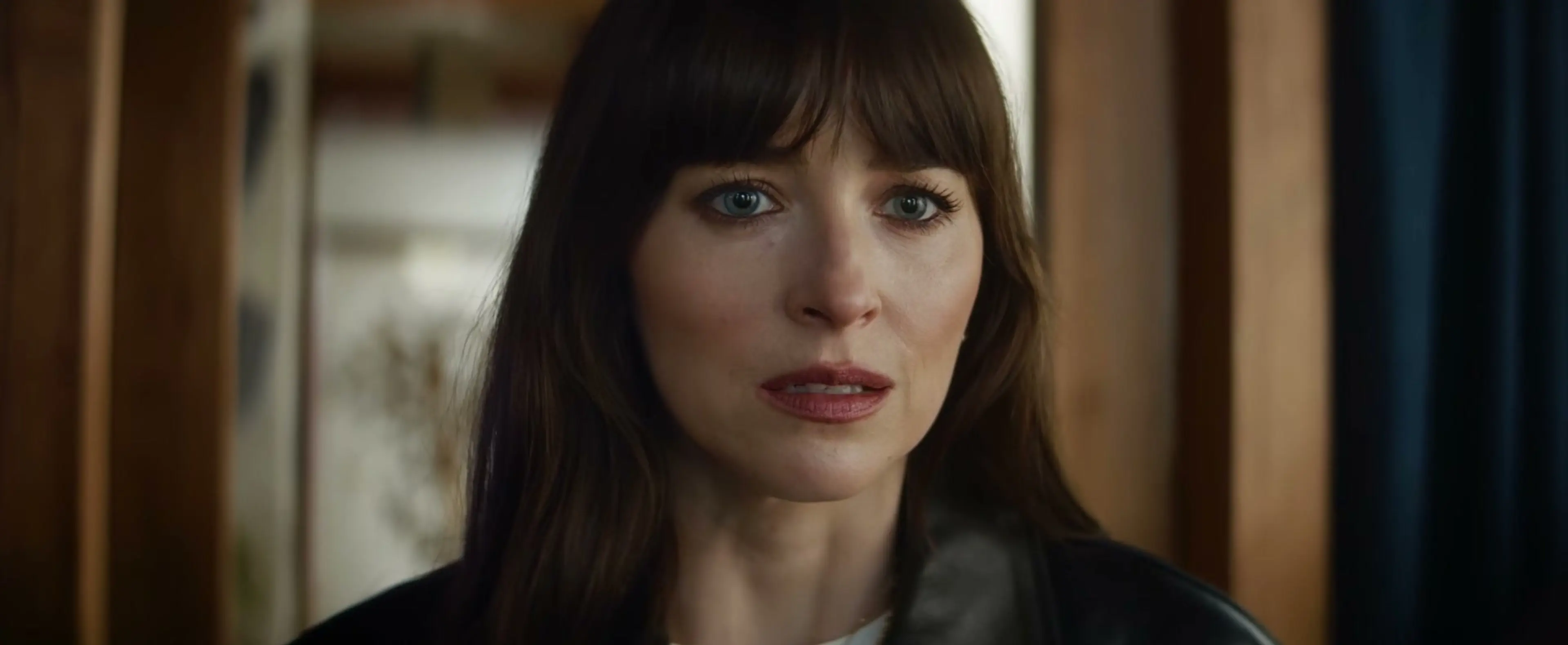 Dakota Johnson as Lowen reacts inside the Crawford house.
