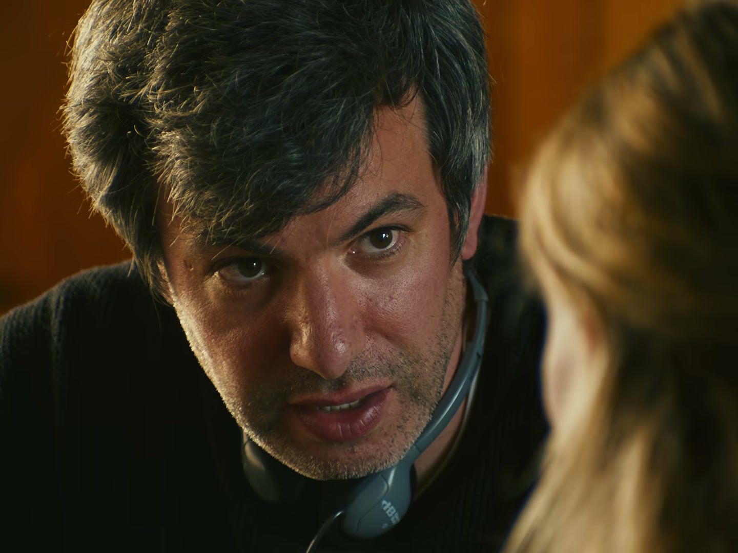Nathan Fielder leans across a table in You Can See Everything.