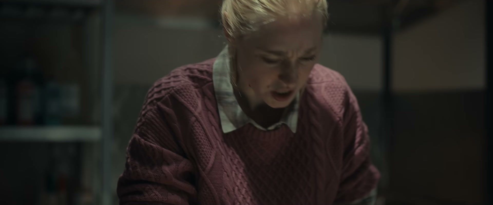 A woman in a rose-colored sweater leans forward in The Cycle trailer.