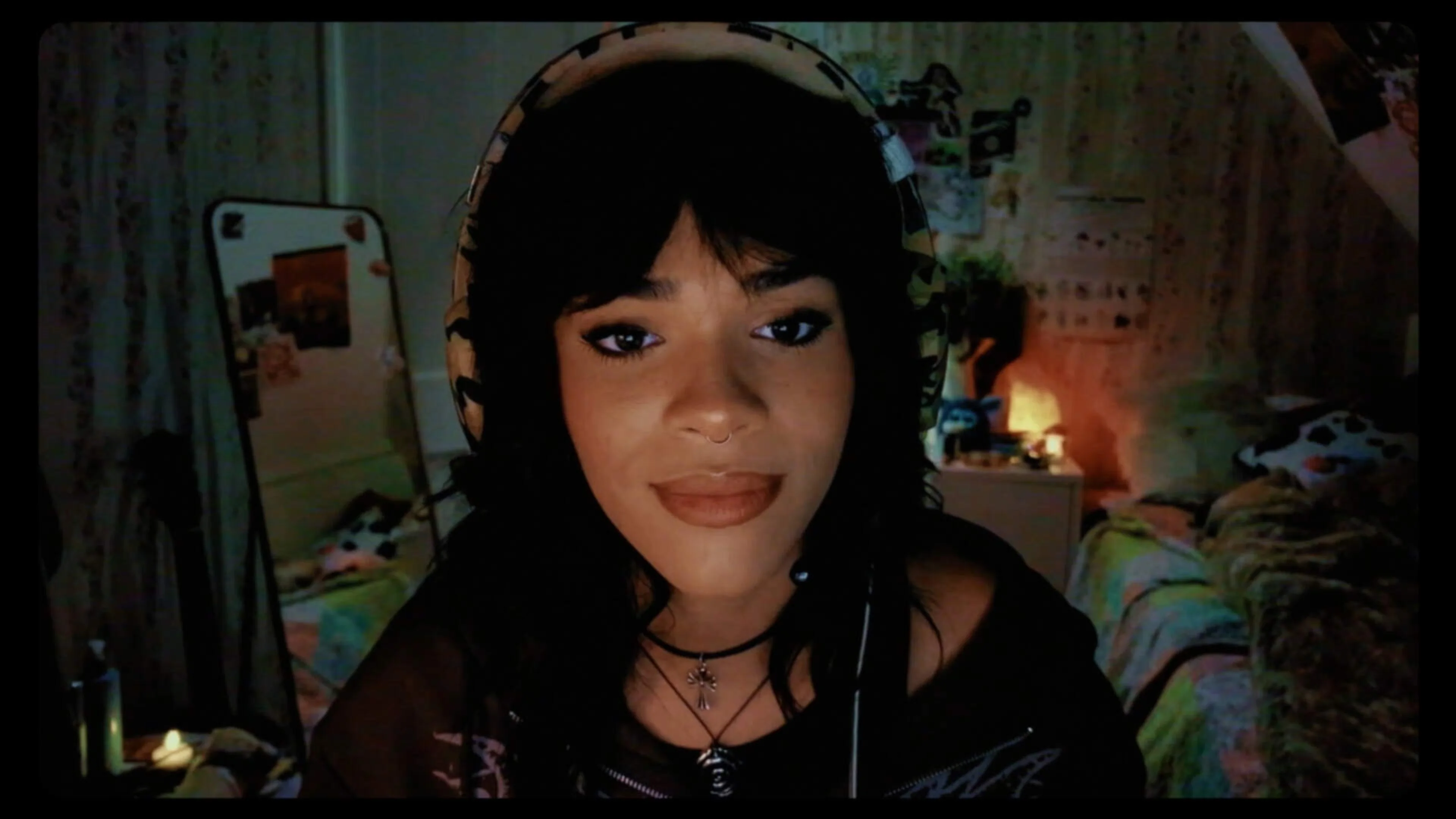 Alex wears headphones while speaking from a bedroom.