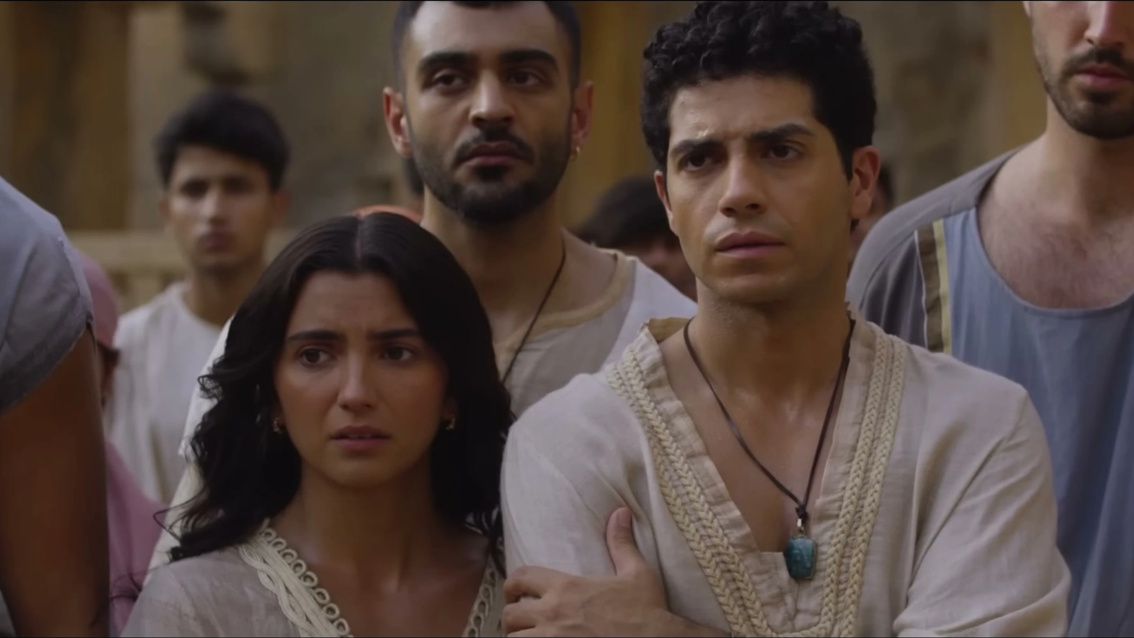 Mena Massoud as Daniel stands with Susanna and other young exiles in Babylon.
