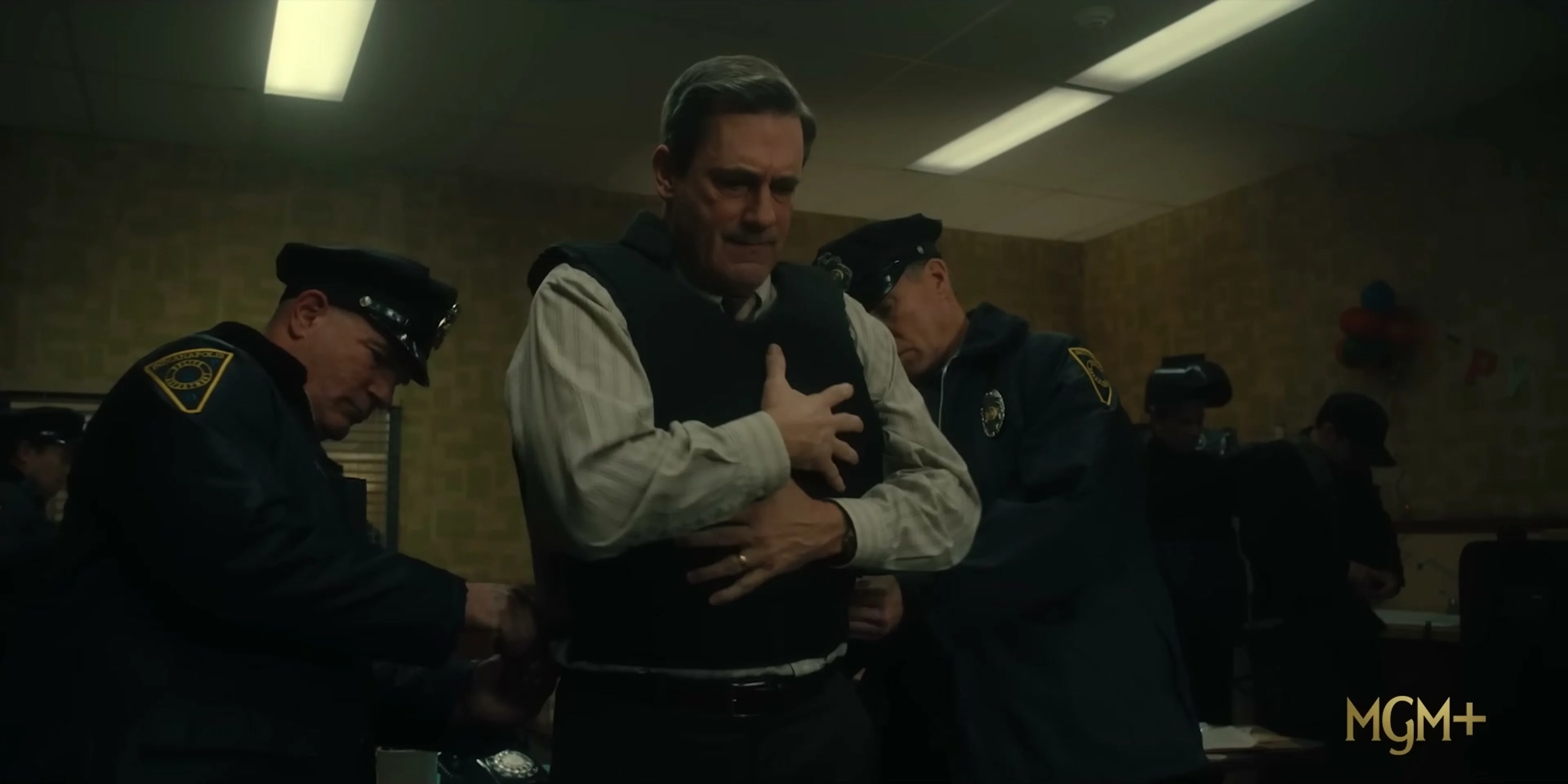 Police officers secure Fred Heckman after a tense moment in American Hostage.