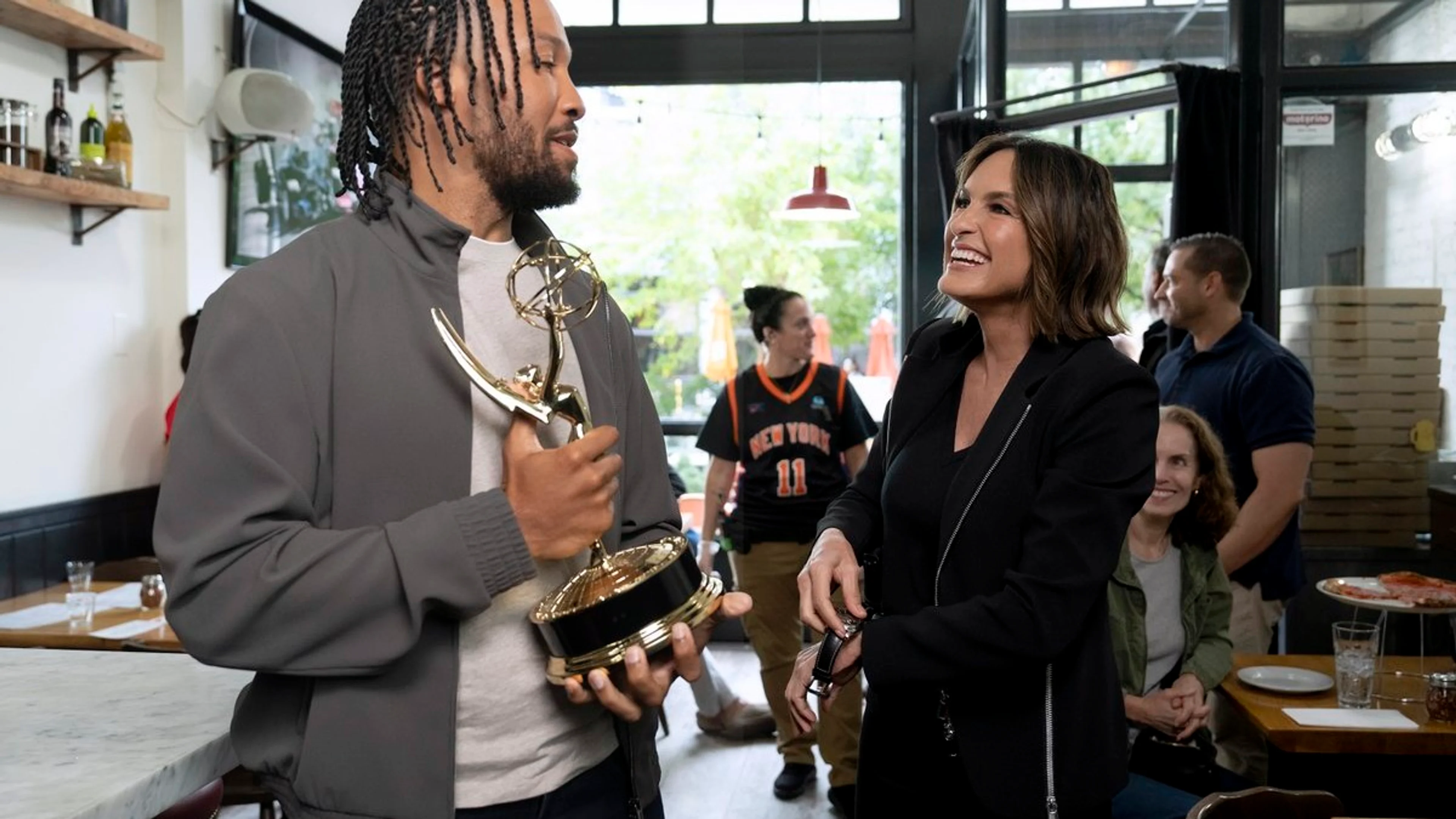 Jalen Brunson holds an Emmy prop beside Mariska Hargitay on the Law & Order: SVU set.