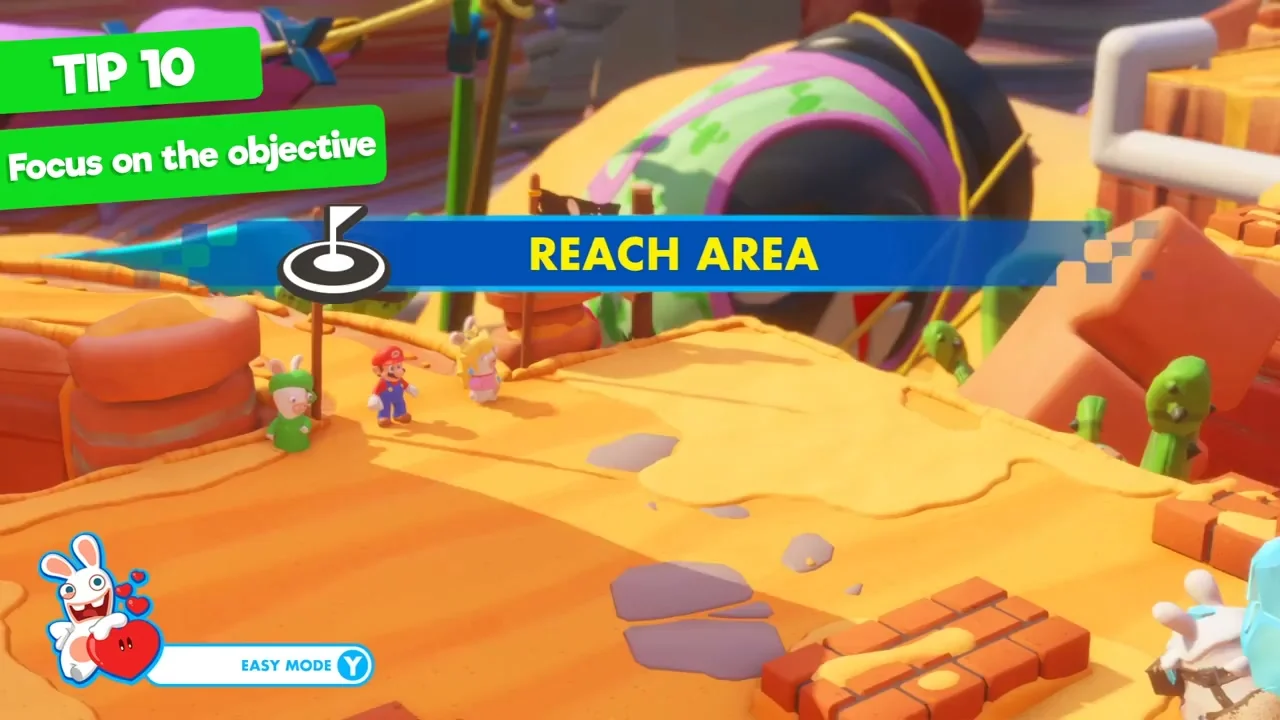 Ubisoft tutorial shows Reach Area in a blue banner above heroes on a desert map.