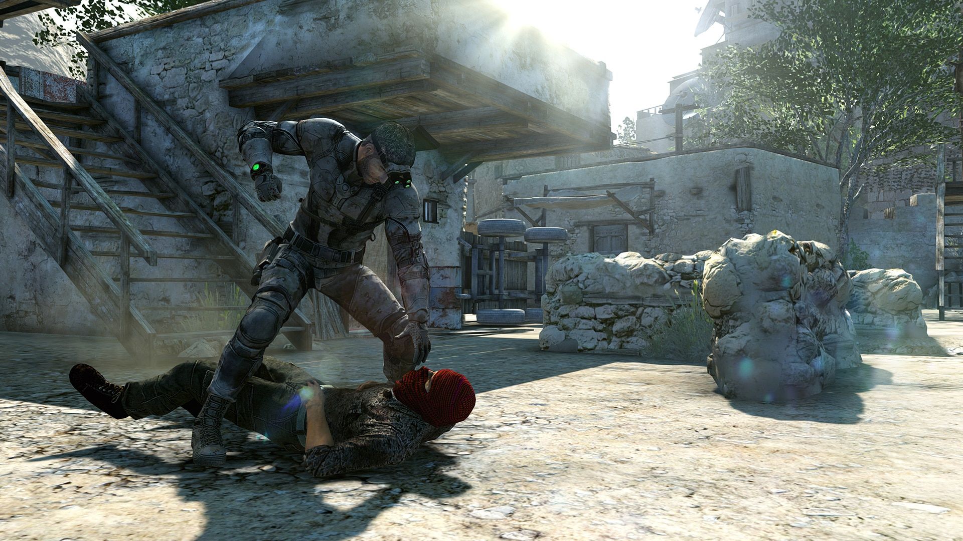 Sam Fisher grapples with an enemy in a bright ruined courtyard.
