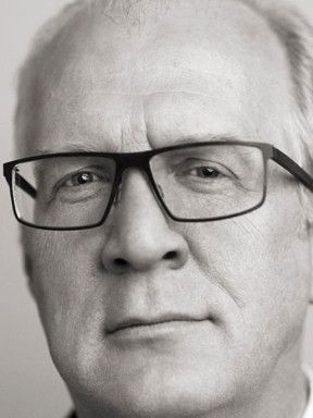Black-and-white portrait of Tracy Letts wearing glasses.