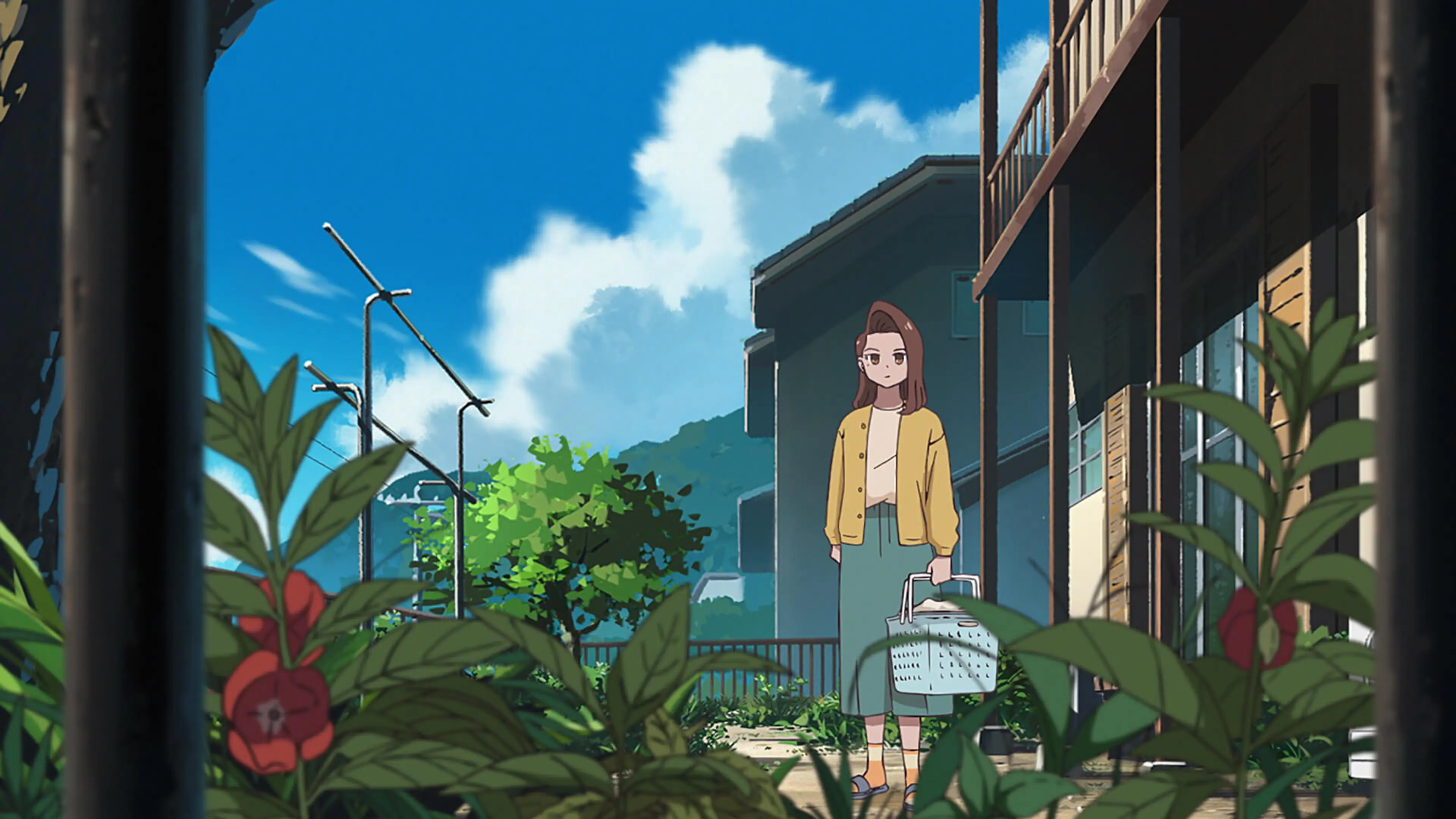 Nana holds a white basket outside a wooden home, with red flowers in the foreground.
