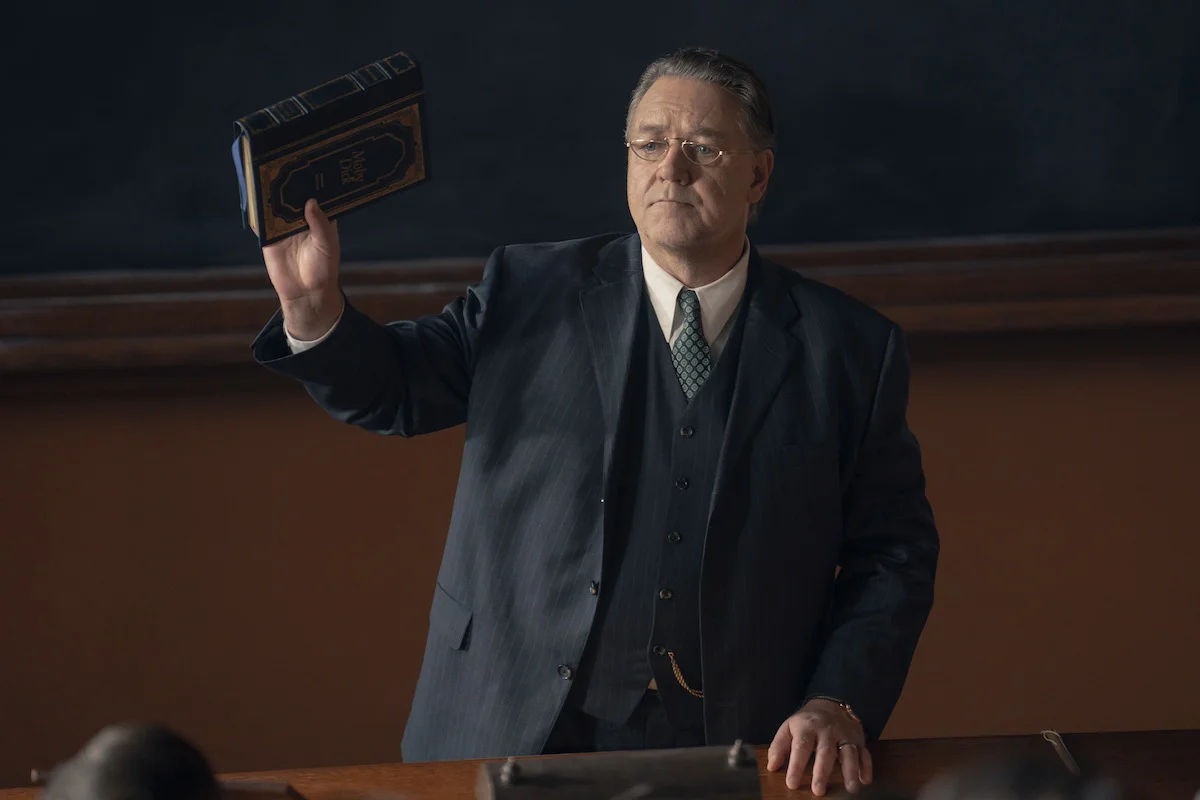 Russell Crowe as Henry Murray holds up Moby-Dick in a Harvard classroom.