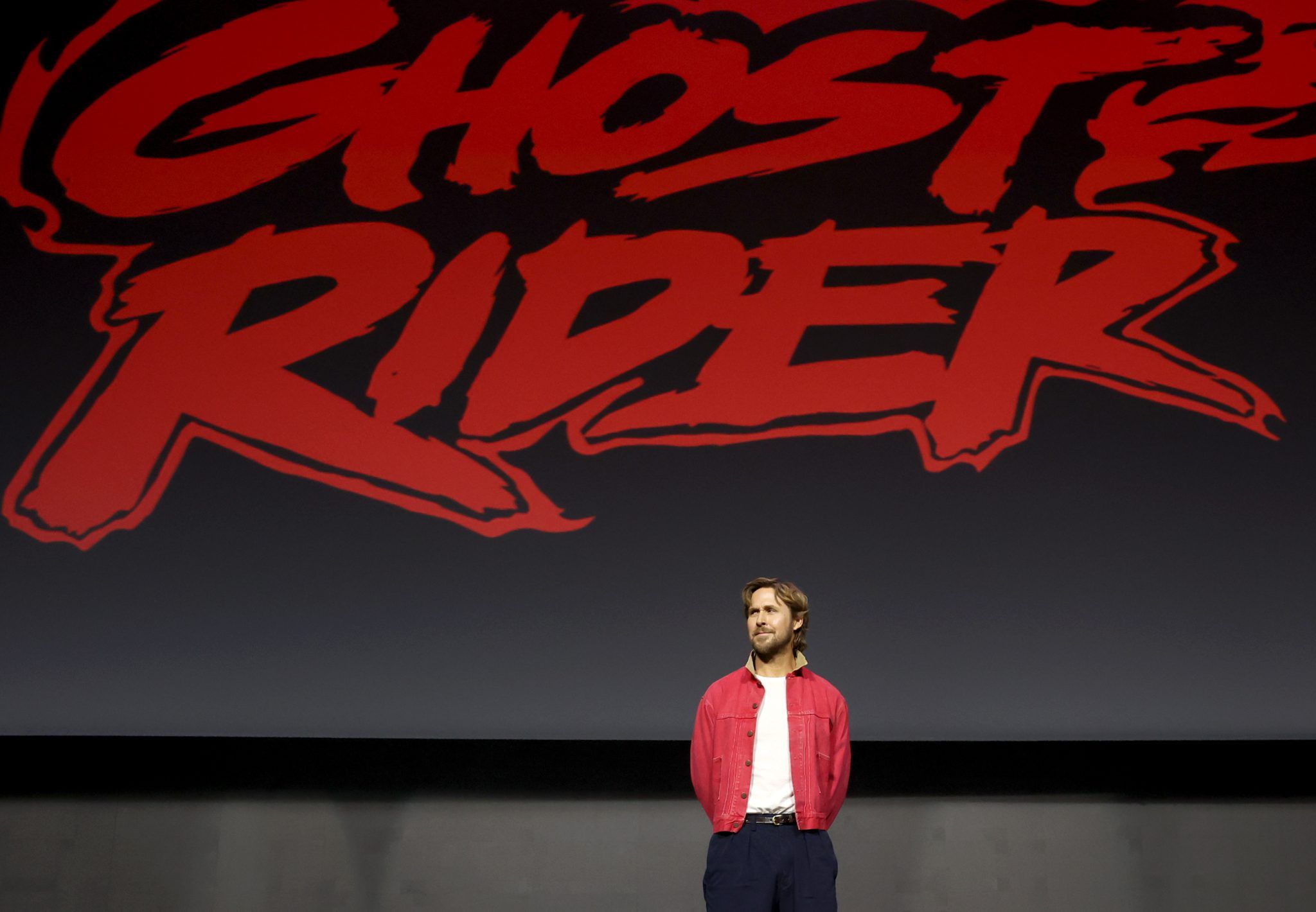 Ryan Gosling stands beneath the Ghost Rider title during Marvel Studios' 2026 San Diego Comic-Con panel.