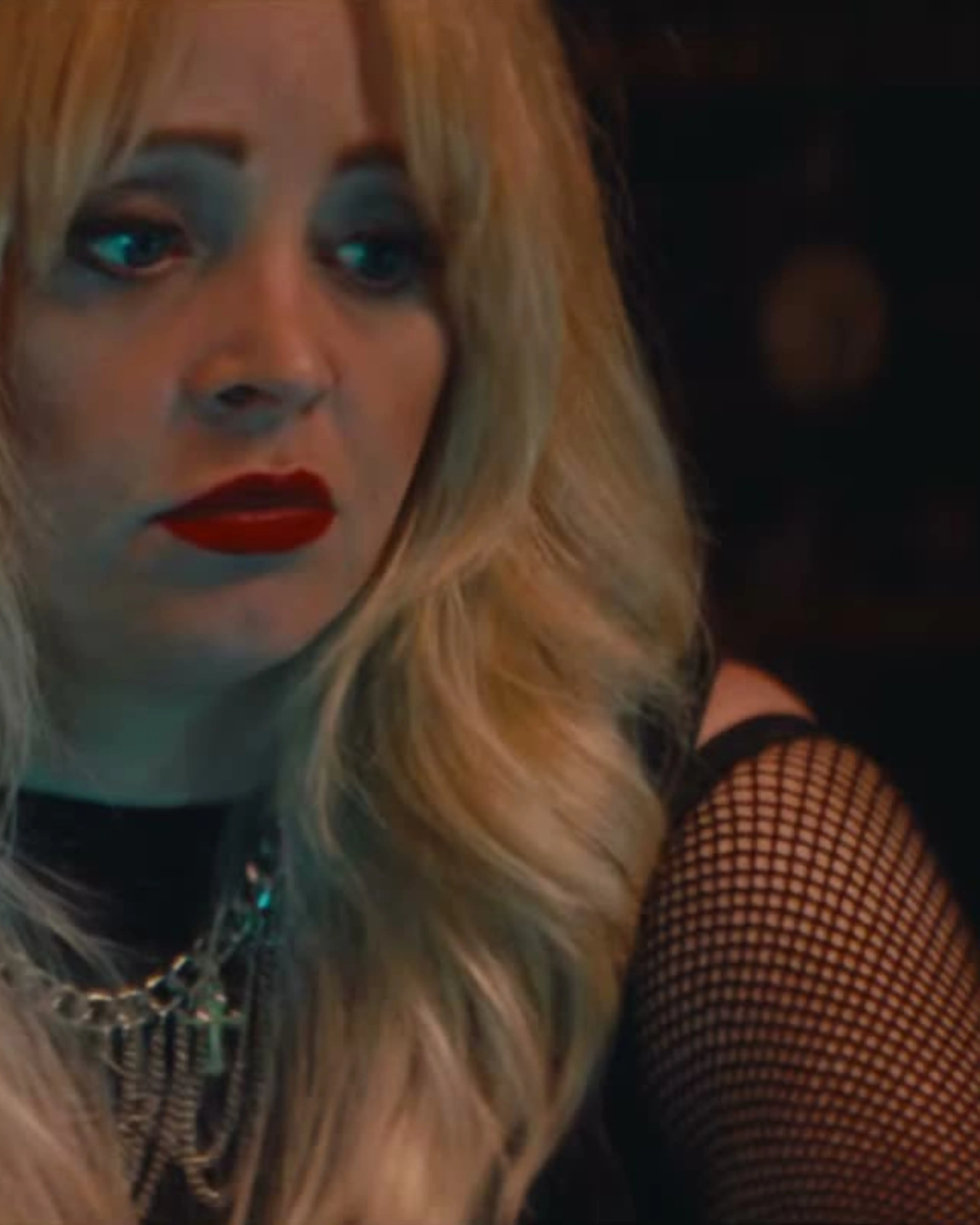 Jessica Dawn Willis at a microphone in Marrow, wearing blonde hair and red lipstick.
