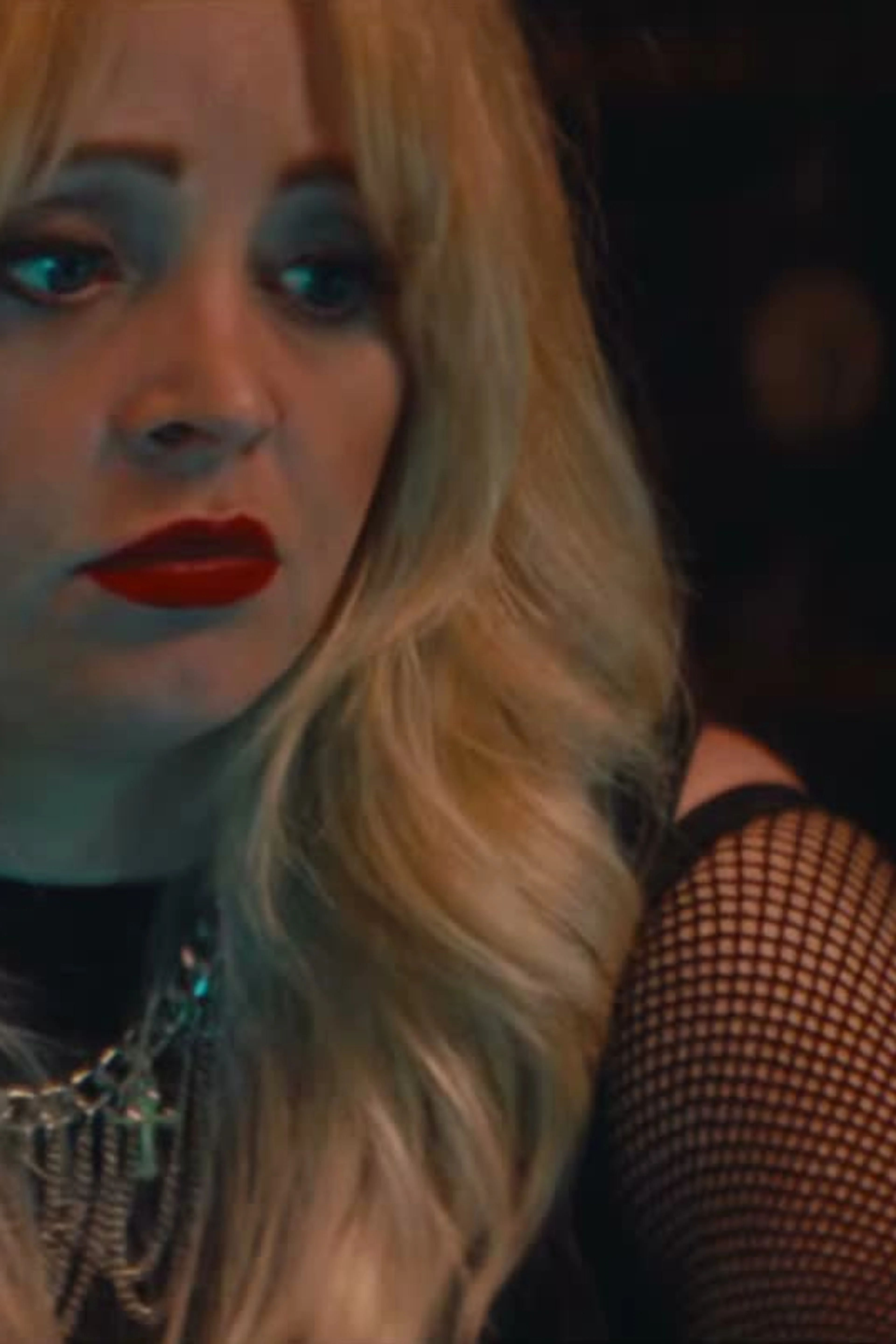 Jessica Dawn Willis at a microphone in Marrow, wearing blonde hair and red lipstick.