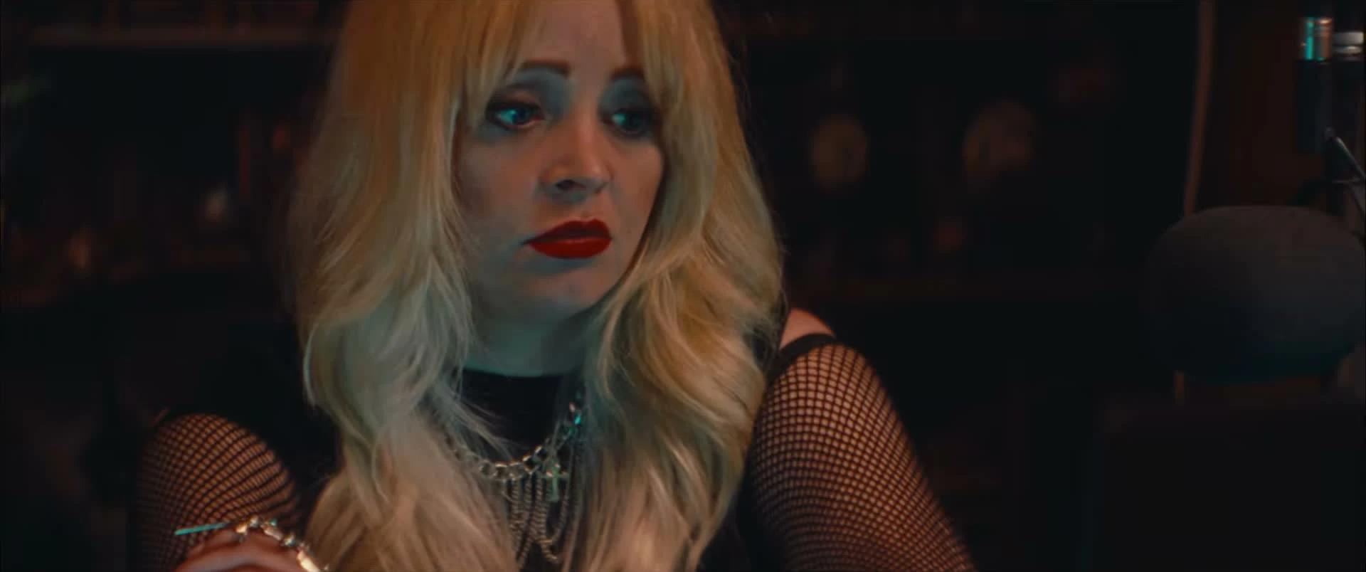 Jessica Dawn Willis at a microphone in Marrow, wearing blonde hair and red lipstick.