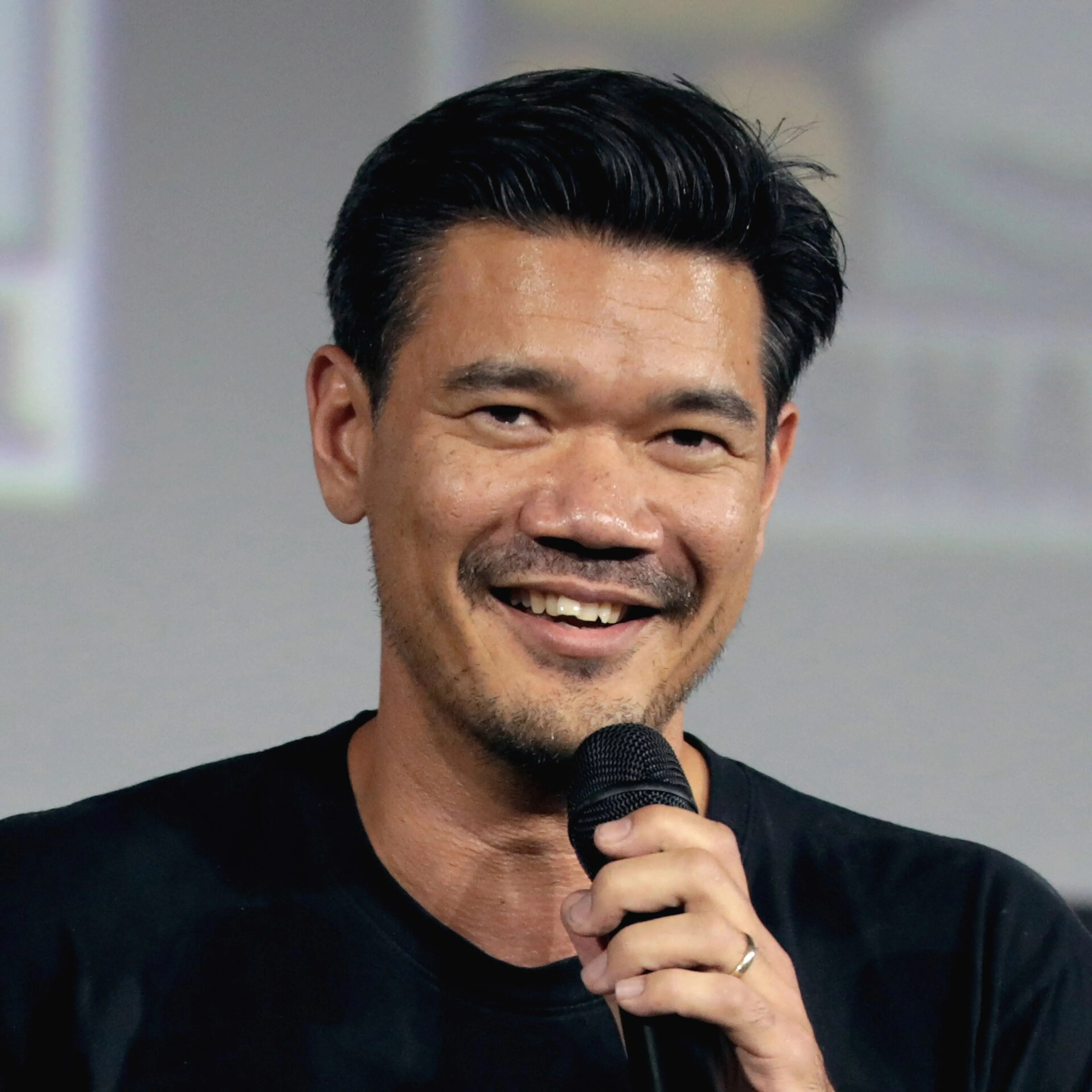 Director Destin Daniel Cretton speaks into a microphone at San Diego Comic-Con.