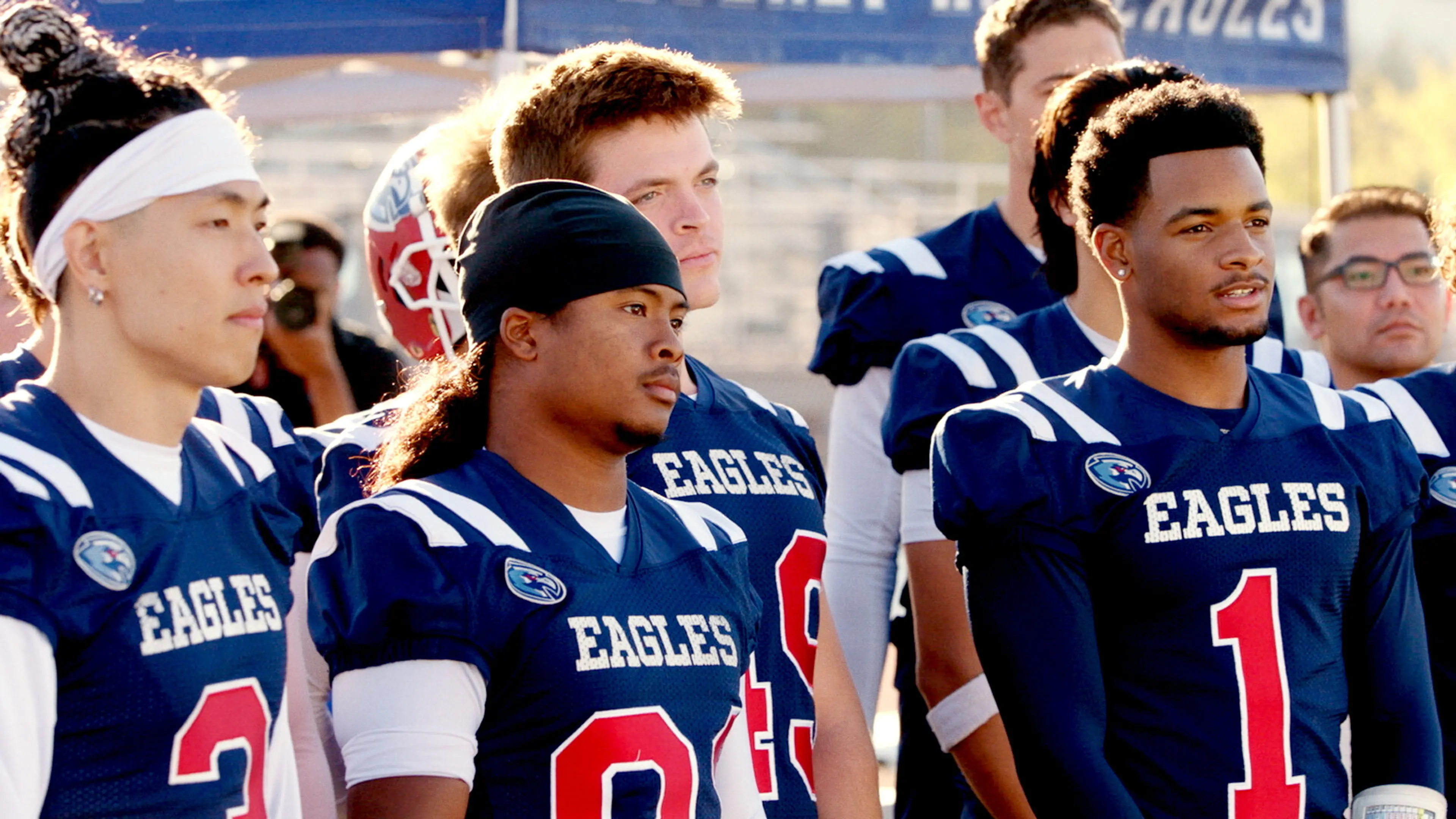 All American cast members stand on a football field in the final season.
