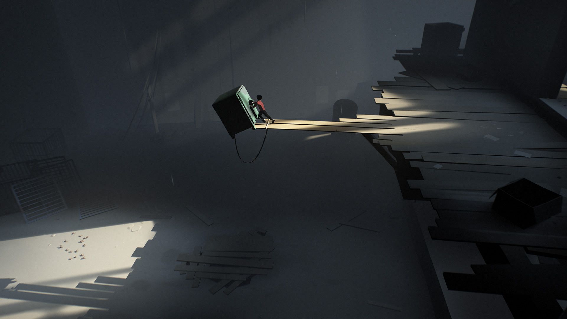 The boy stands below a narrow pool of light in an industrial space.