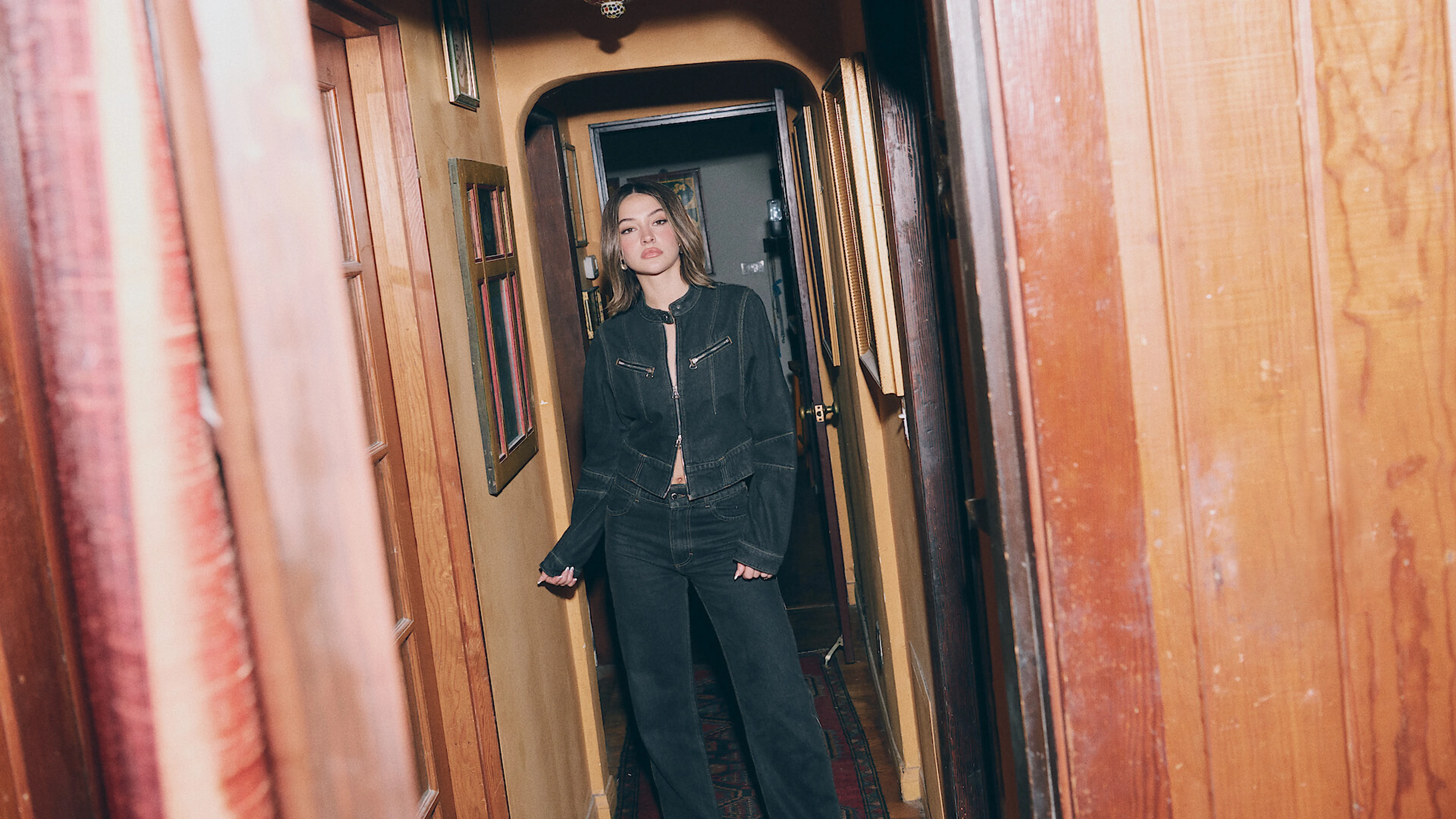 Madelyn Cline standing in a wood-paneled hallway in an official Outer Banks farewell portrait.