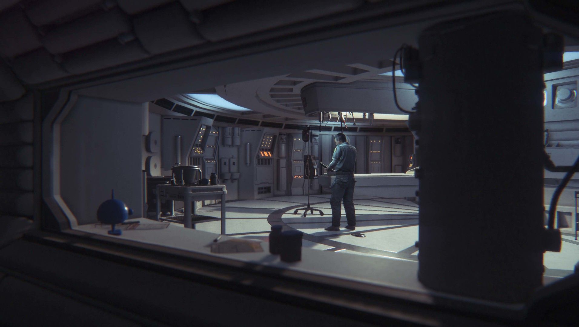 Amanda looks across a room at a person working inside Sevastopol station.