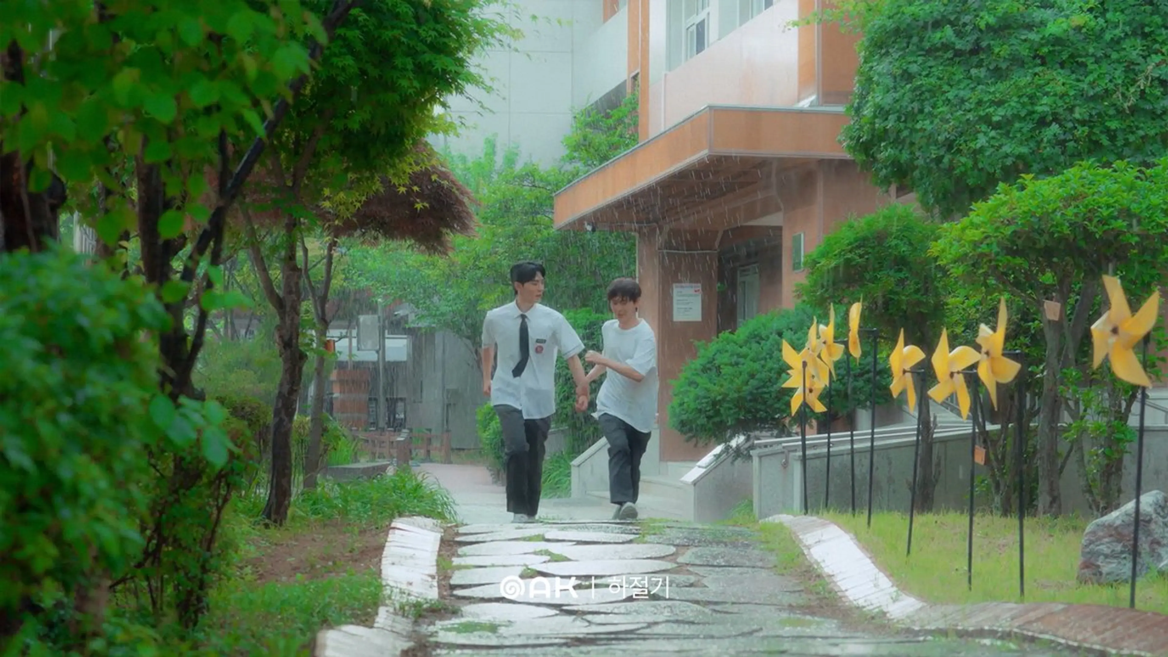 Two friends run together along a wet neighborhood path.