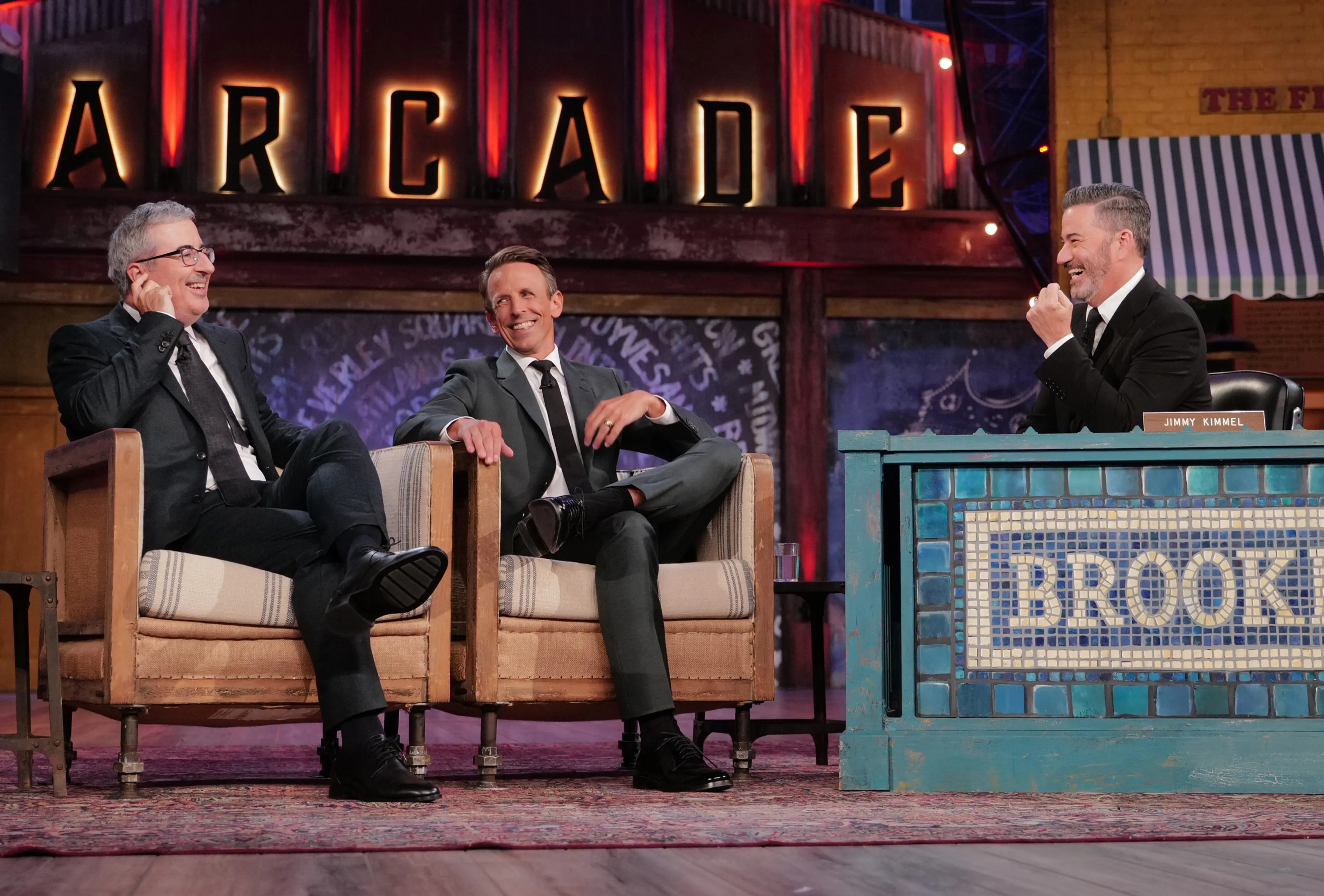 John Oliver, Seth Meyers and Jimmy Kimmel laugh together on the Brooklyn set.