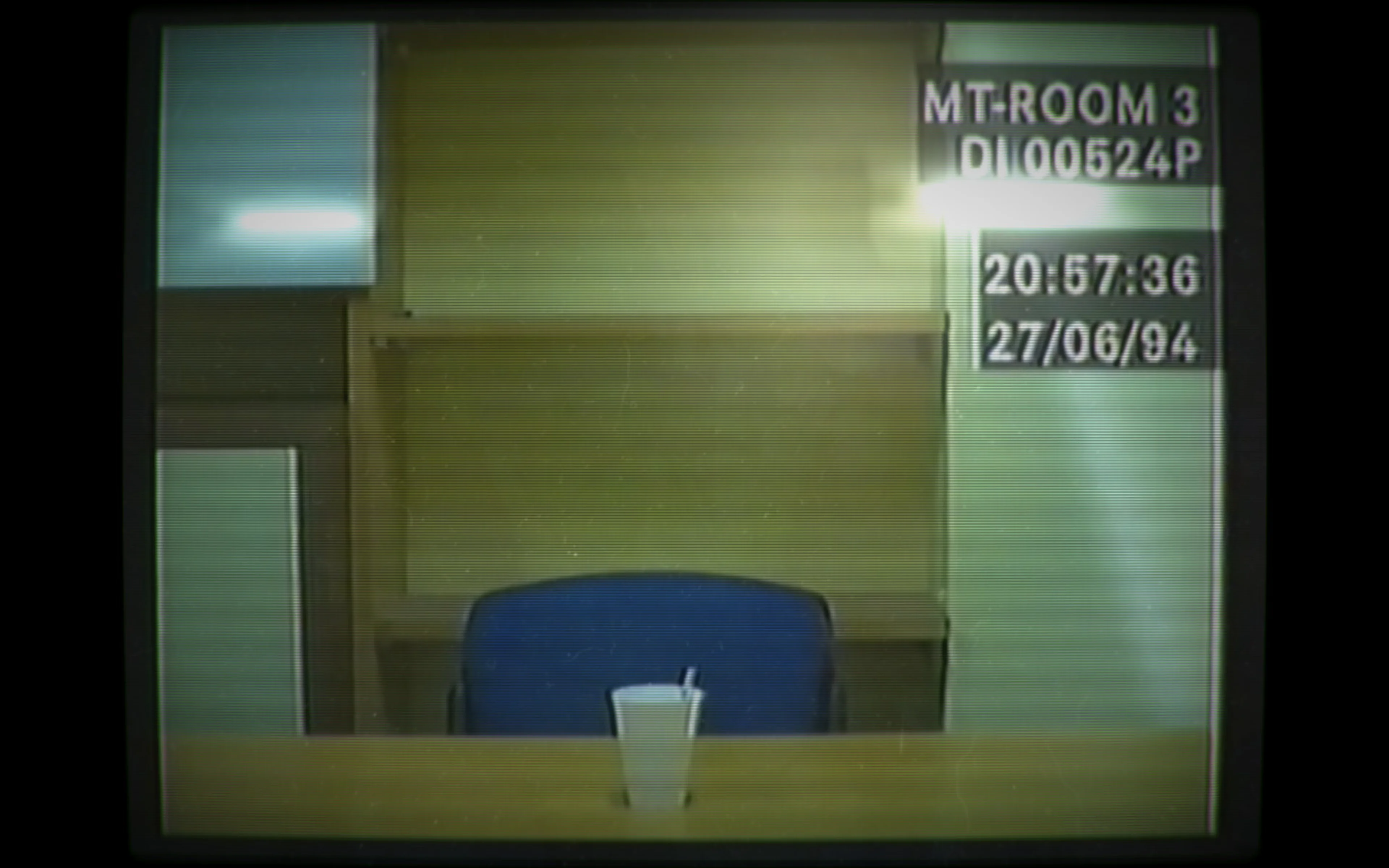 An empty police interview chair and a paper cup are visible in a dated Her Story recording.
