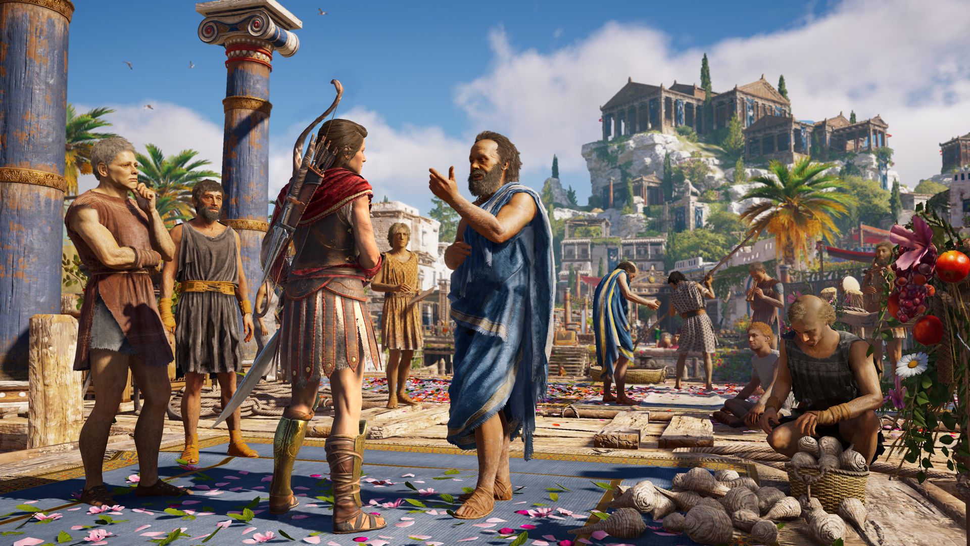 A cloaked mercenary talks with a man in a busy Greek town square.