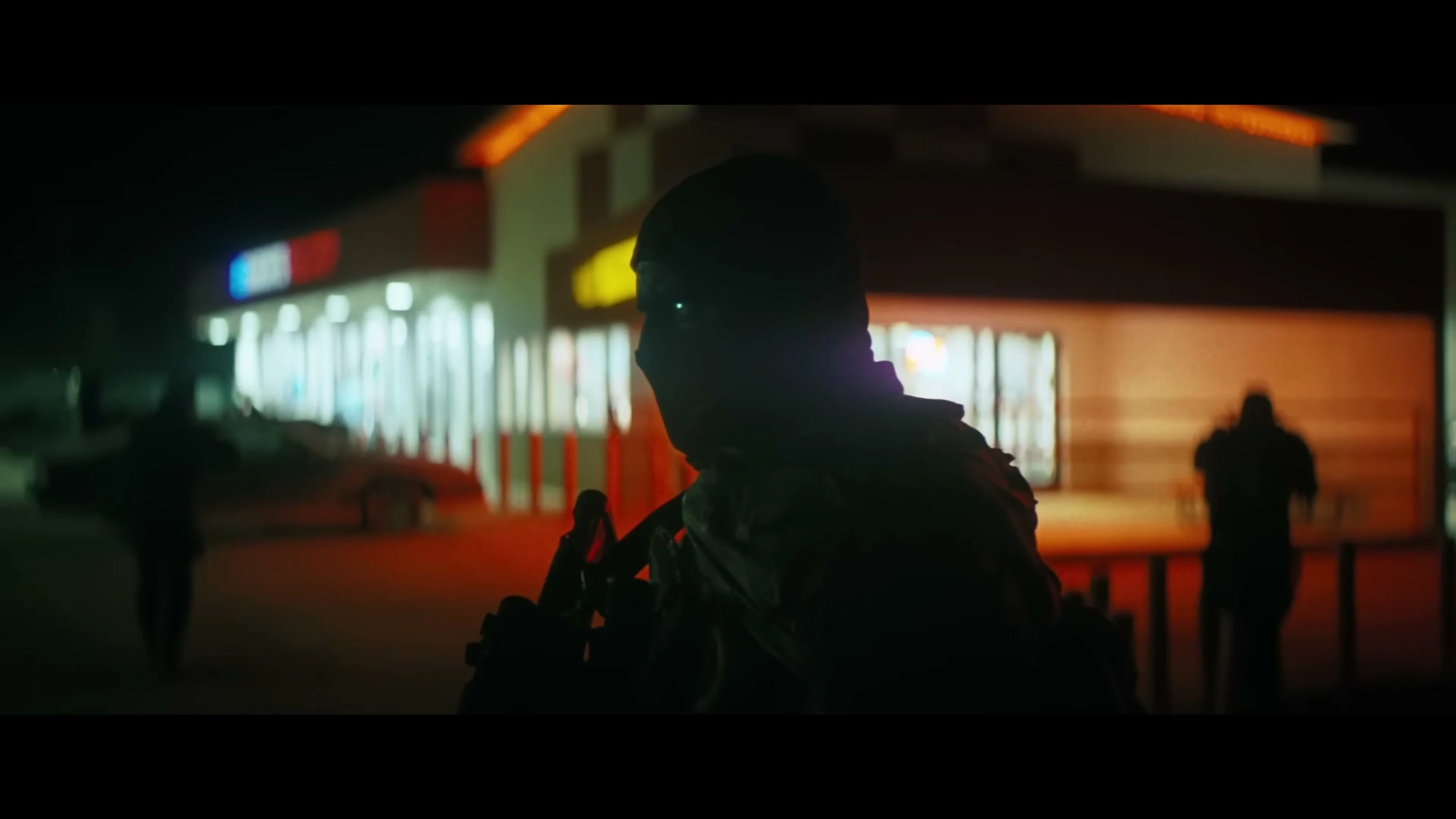 A masked super soldier walks toward a brightly lit fuel stop in Onslaught.