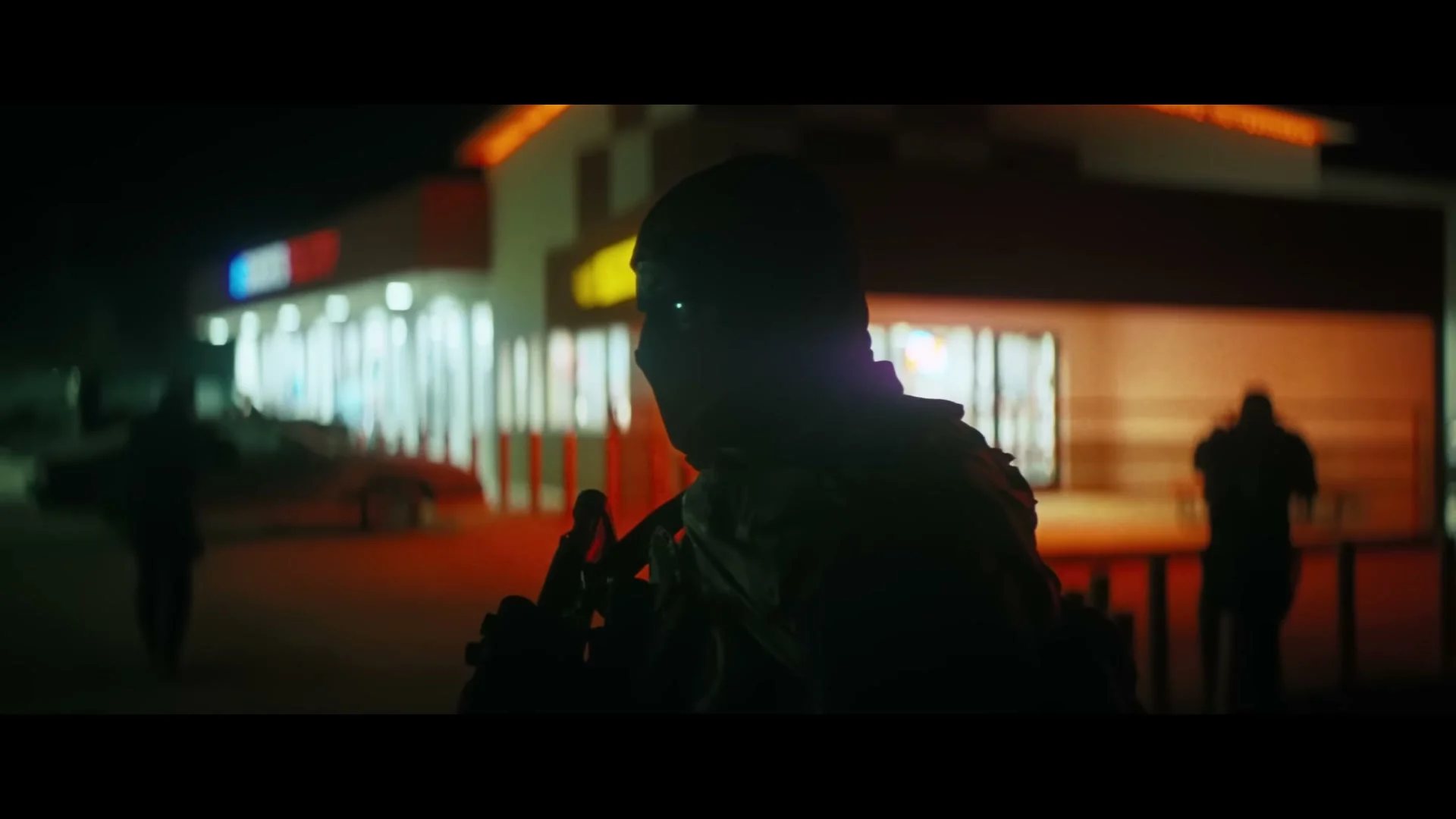 A masked super soldier walks toward a brightly lit fuel stop in Onslaught.